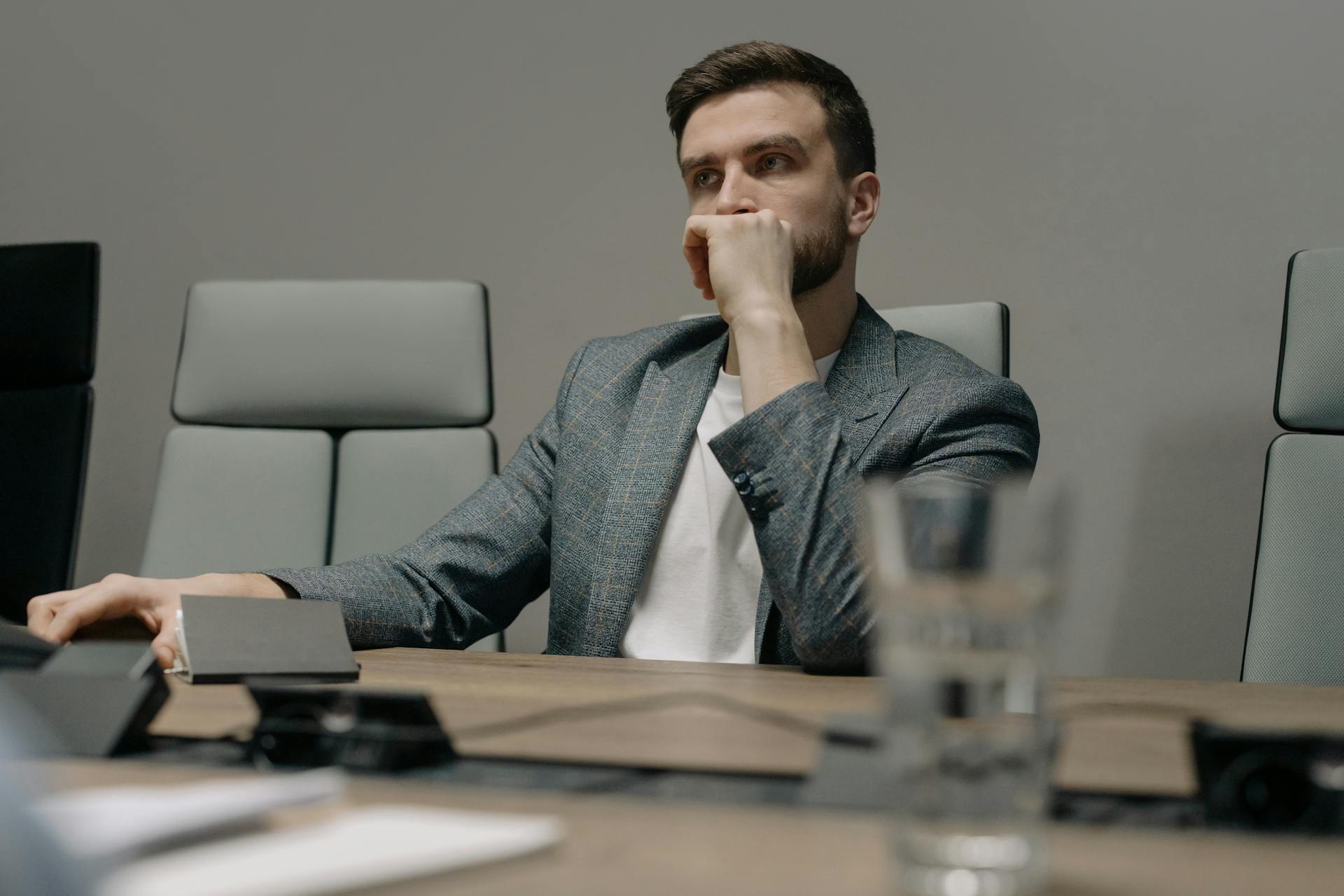A man looks thoughtful while sitting in his office | Source: Pexels