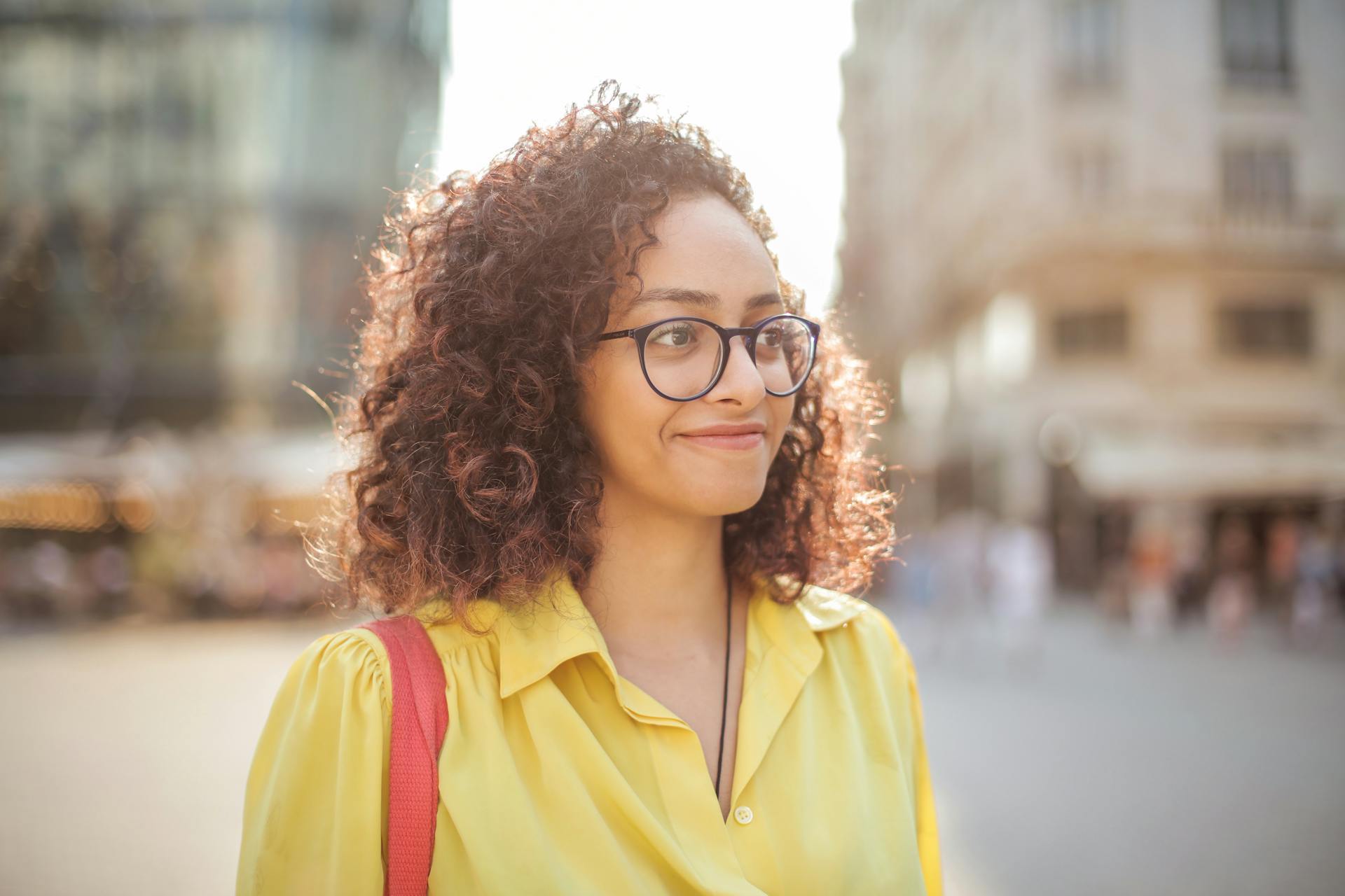 A woman on a sidewalk smiling at someone | Source: Pexels