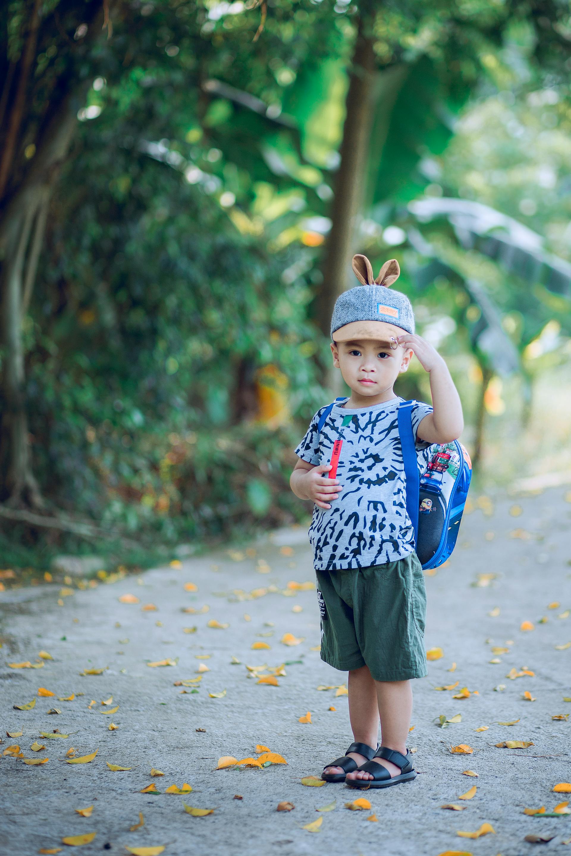 A small boy wearing a backpack and a hat with animal ears | Source: Pexels