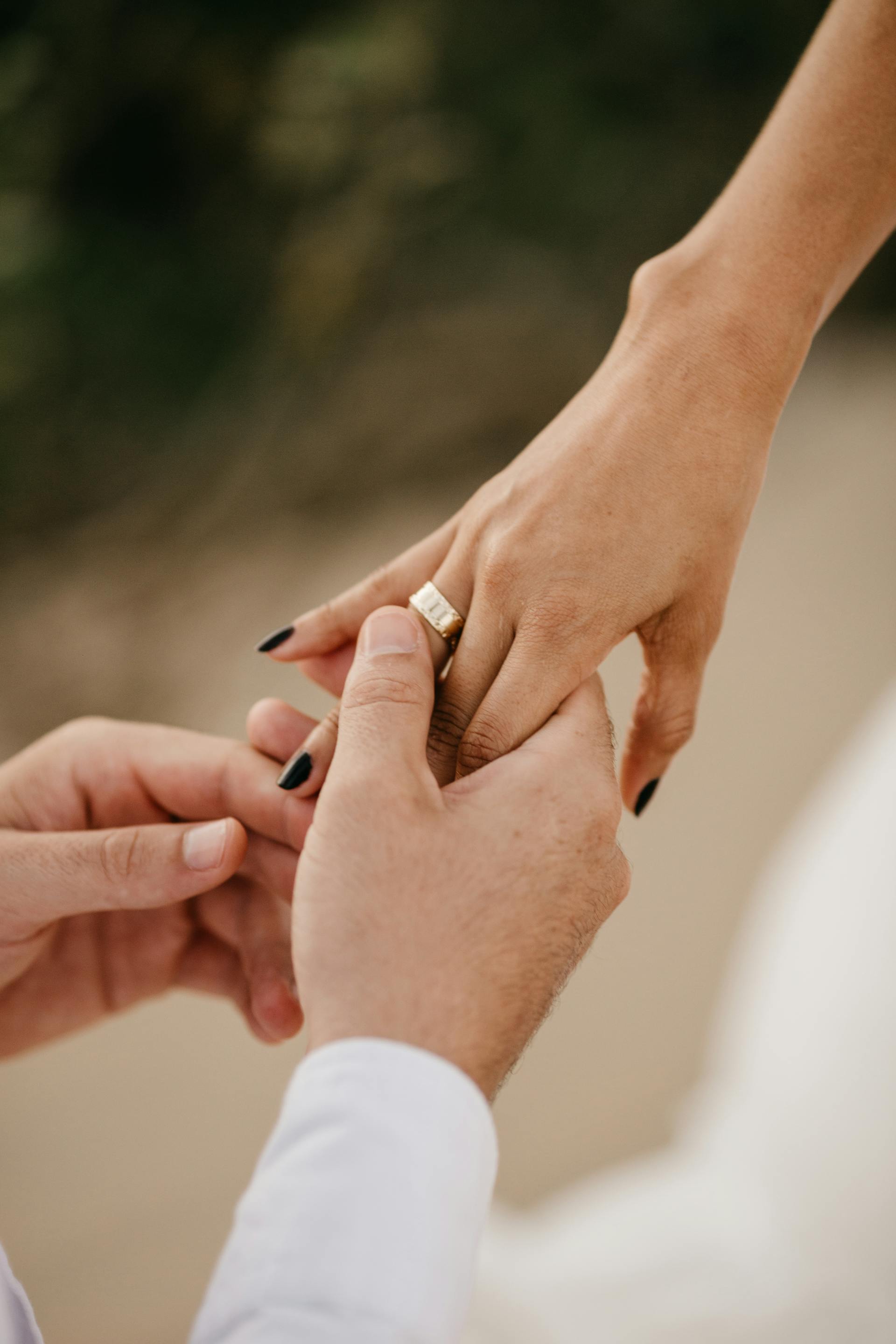 A man slipping an engagement ring on a woman's finger | Source: Pexels