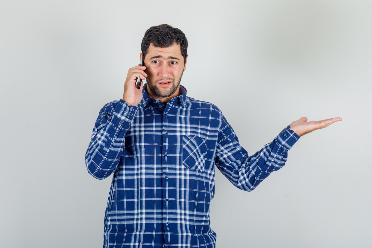 An anxious man talking on the phone | Source: Freepik