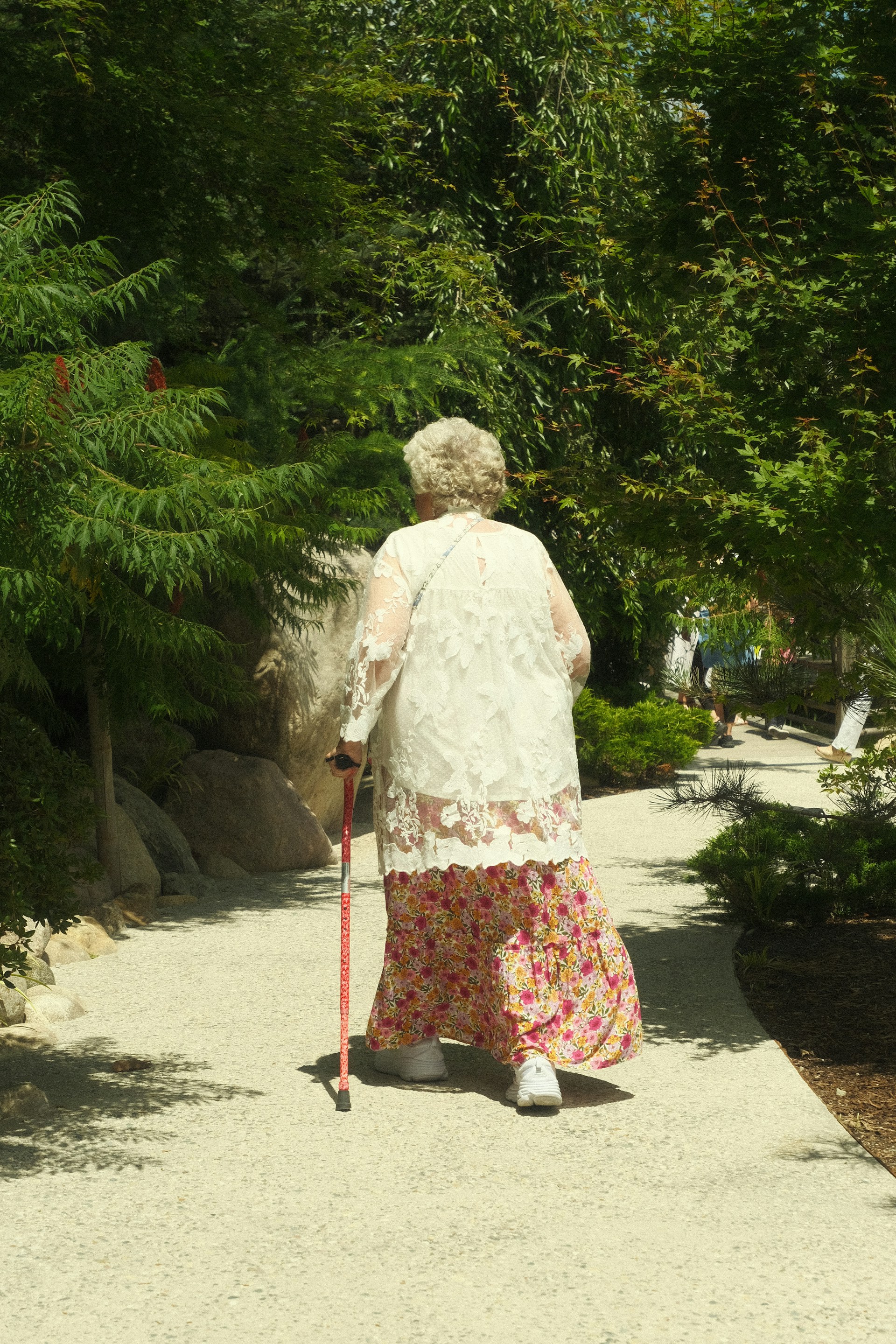 An elderly woman walking on a concrete surface | Source: Unsplash