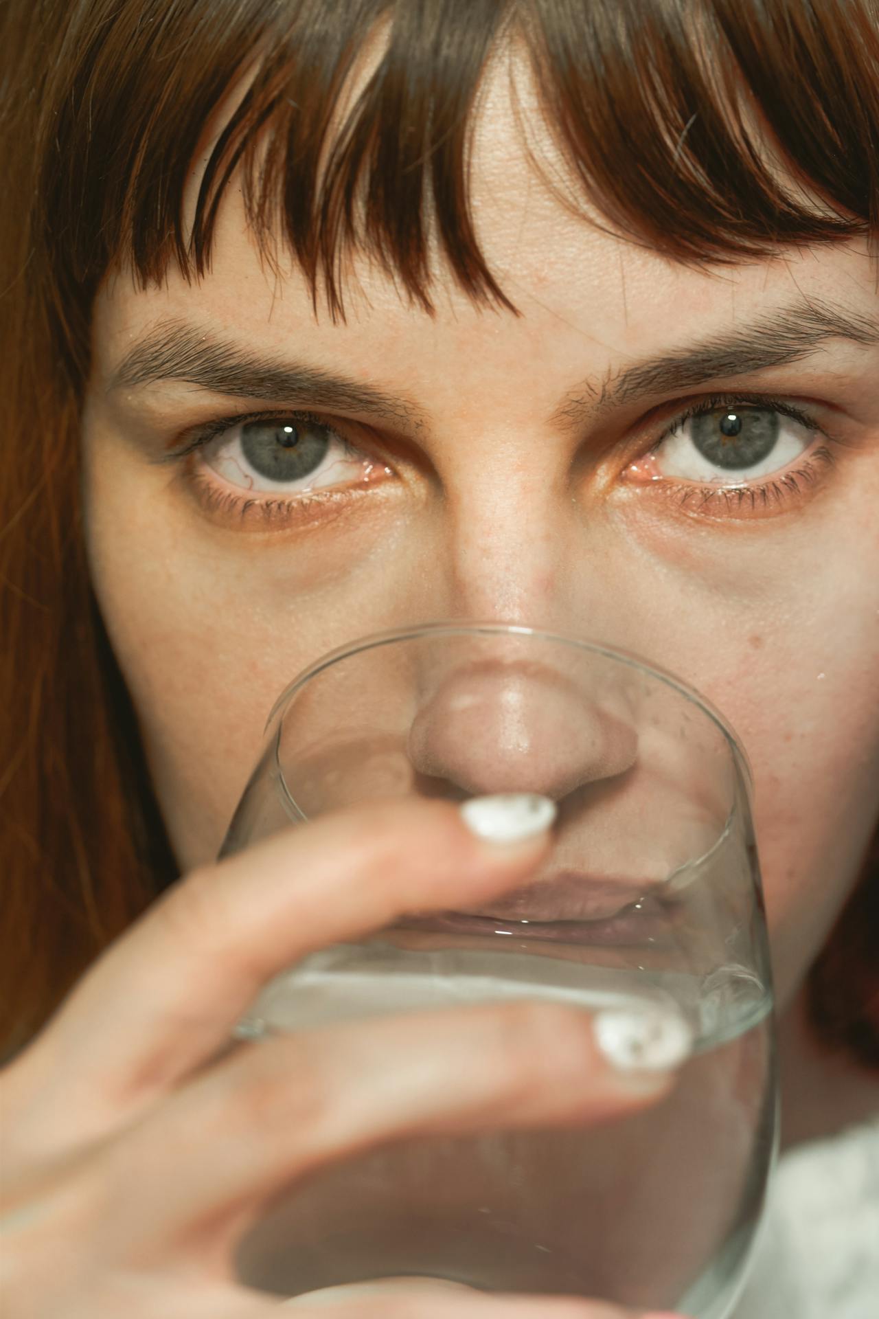 A woman drinking a glass of water | Source: Pexels
