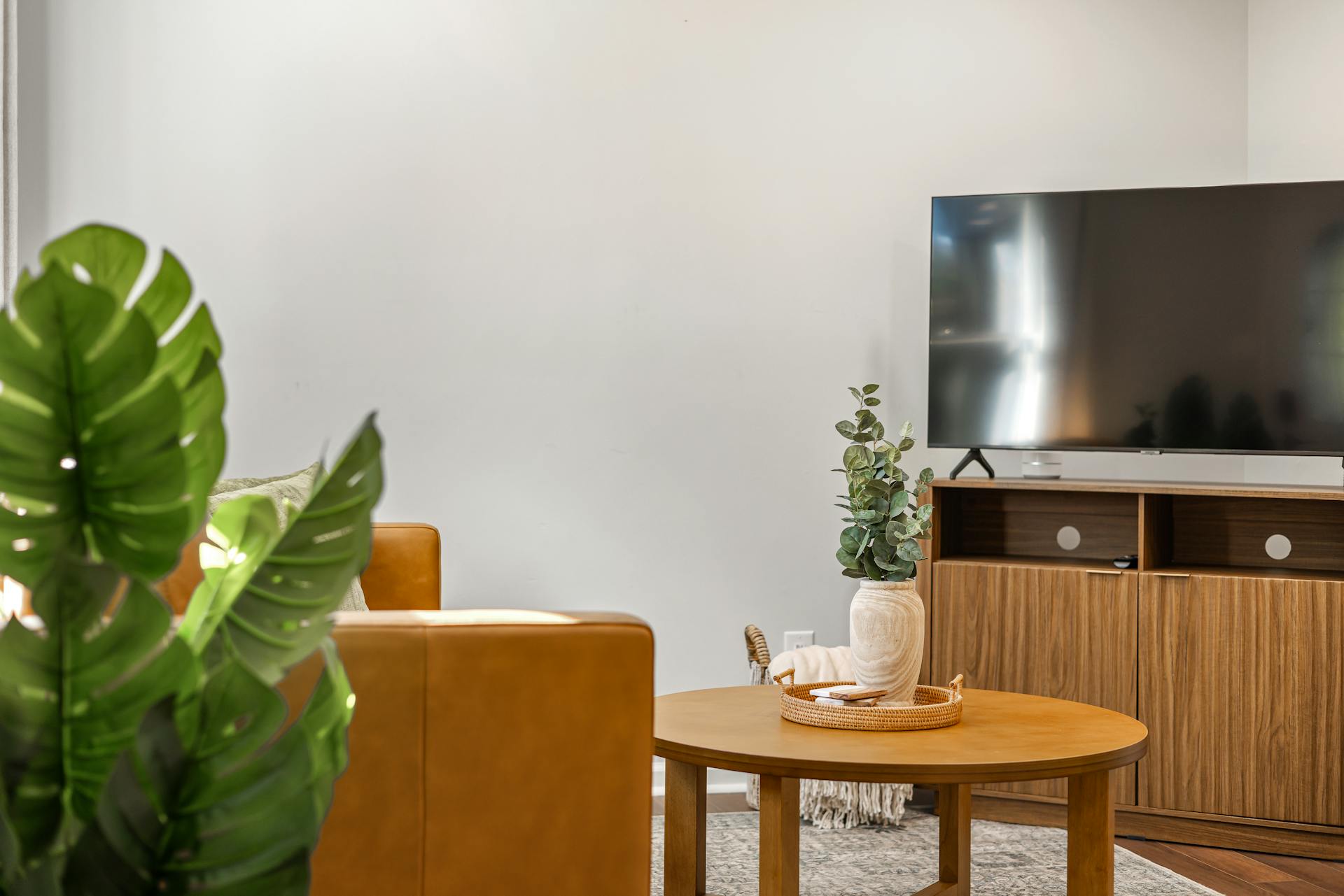 A flat TV on a wooden rack in a room | Source: Pexels
