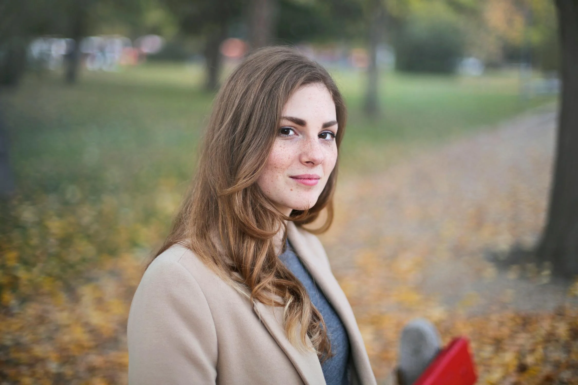 A smiling young woman sitting in a park | Source: Pexels