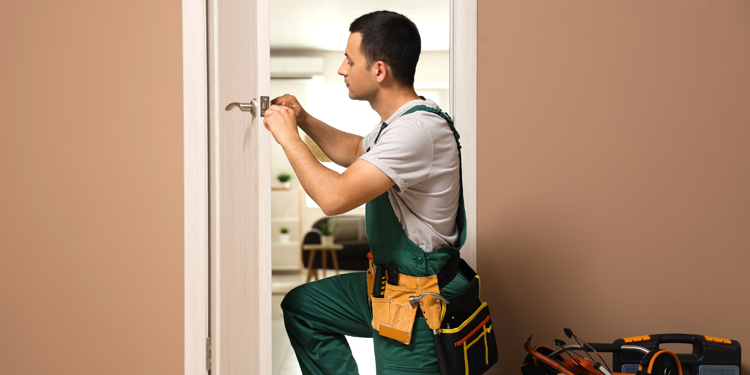 A handyman fixing a door lock | Source: Shutterstock