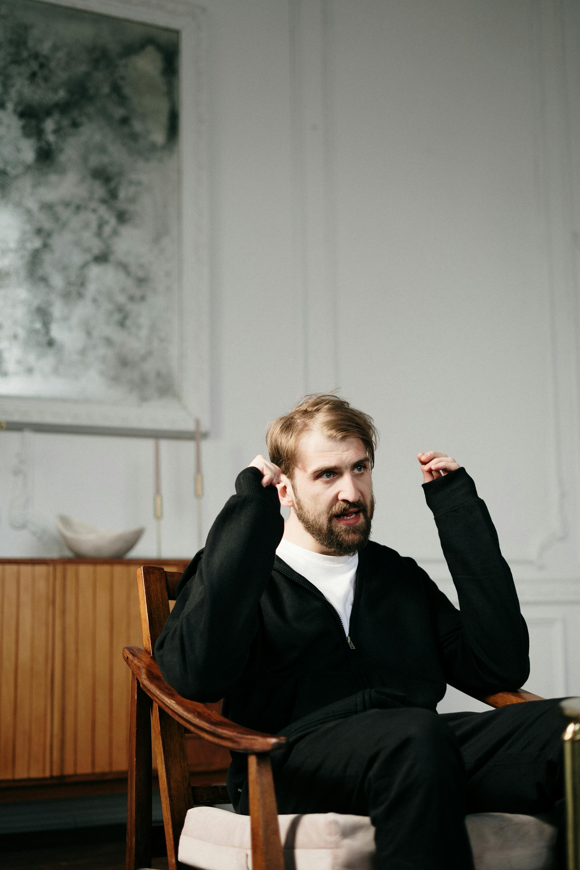 Angry man sitting on a chair in a room | Source: Pexels