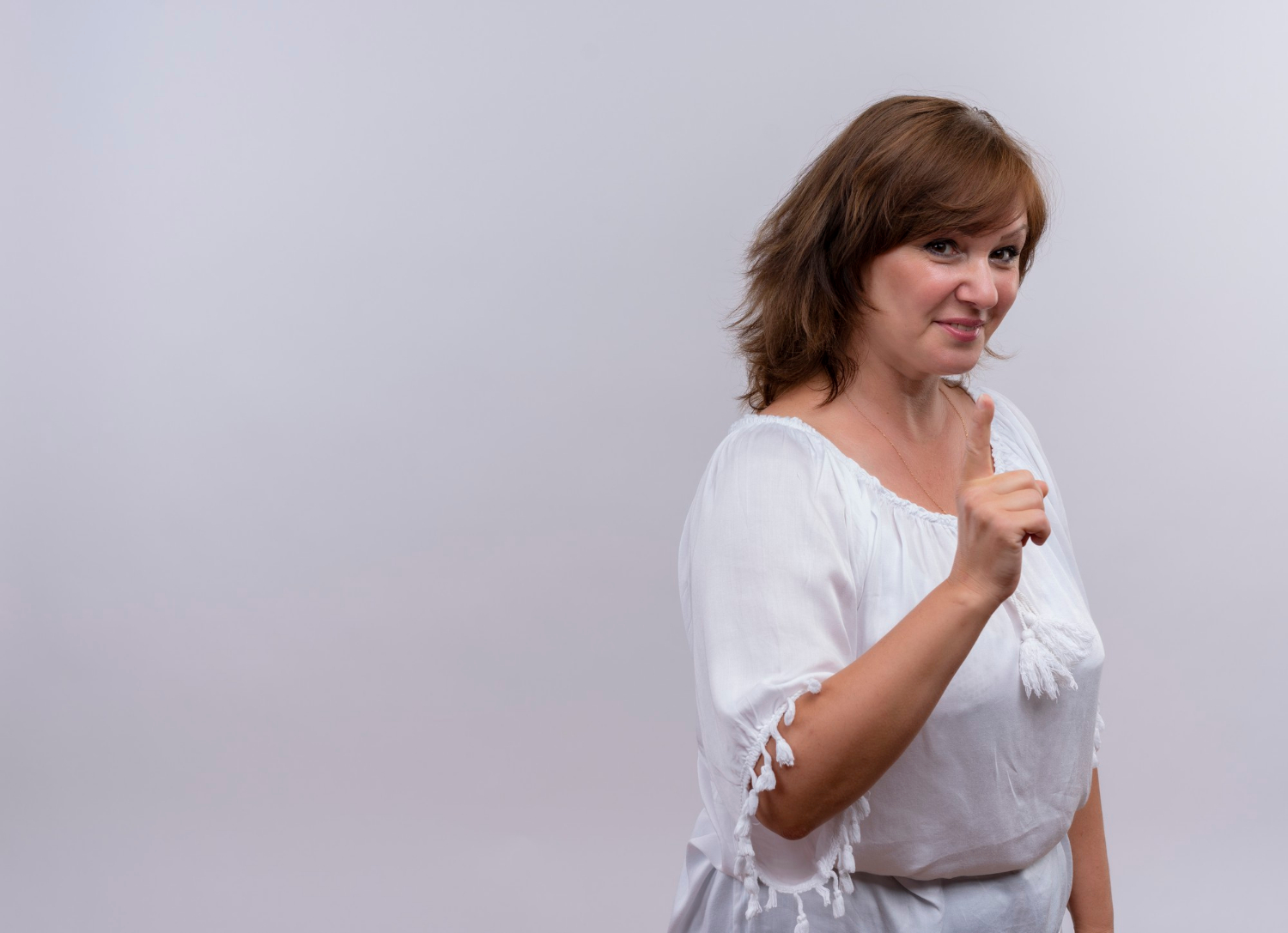 A smiling woman pointing her finger | Source: Freepik