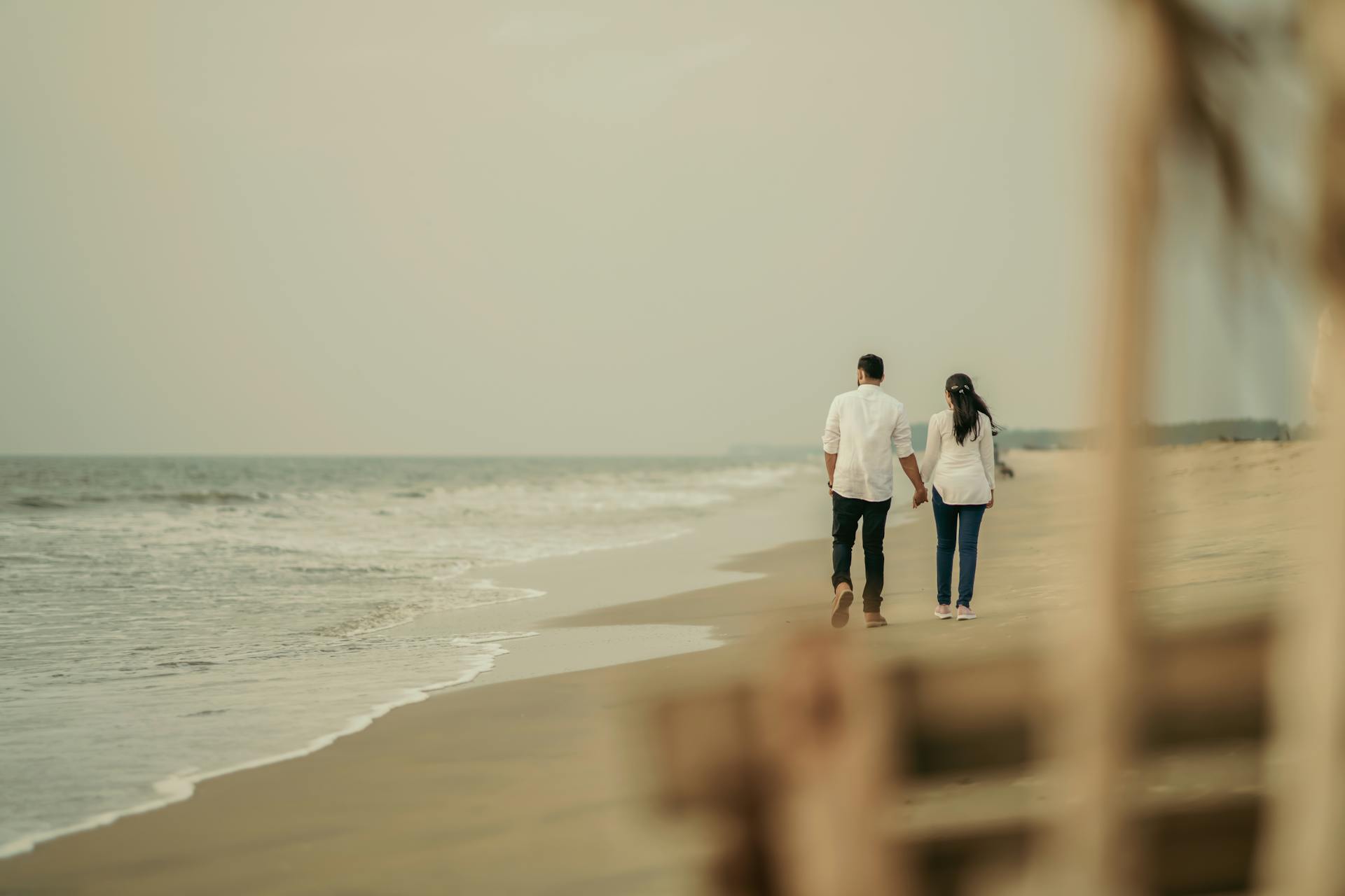 Um casal caminhando na praia | Fonte: Pexels