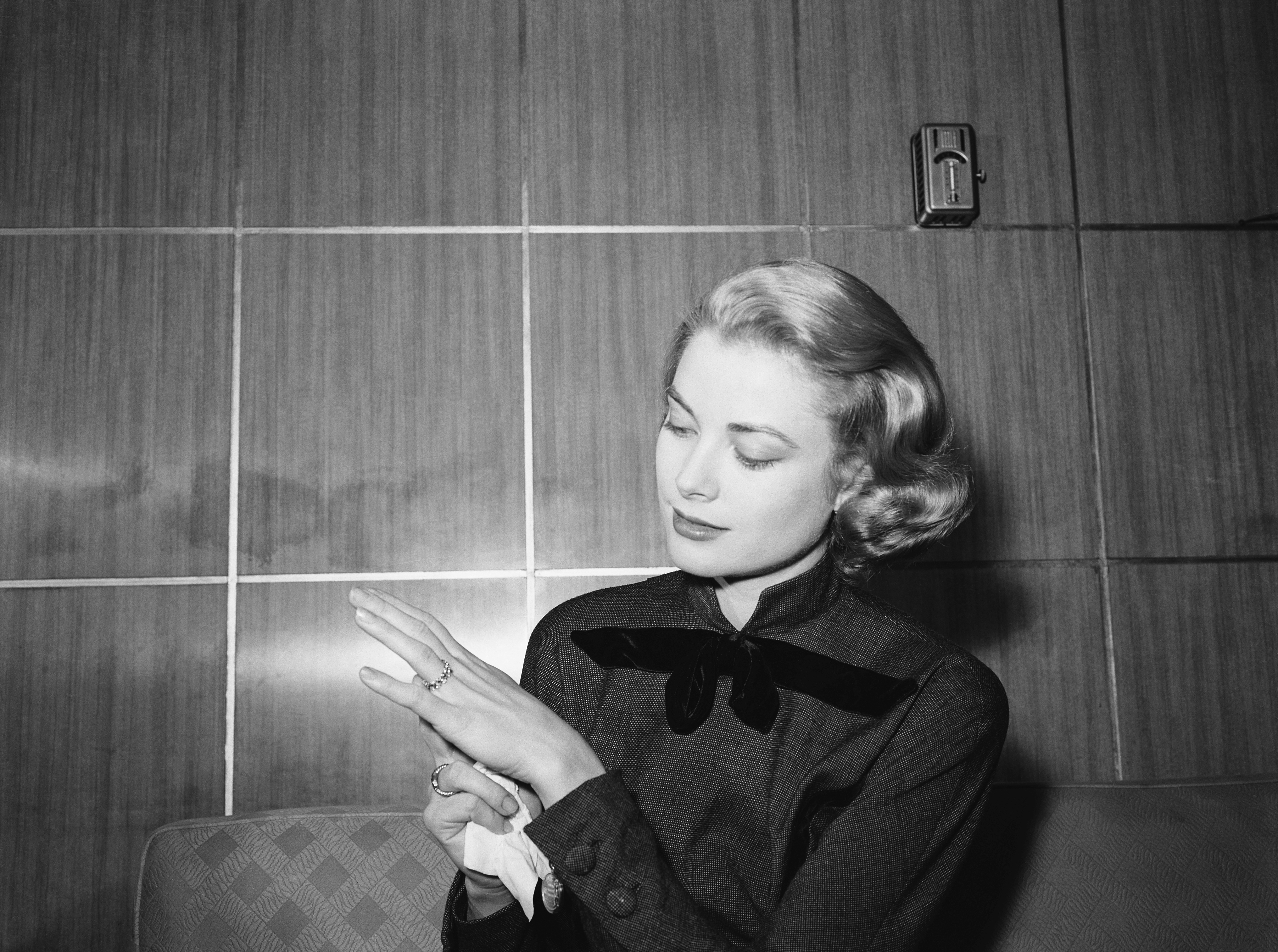 Grace Kelly, en route to Hollywood for movie work, strikes a pose to show off the engagement ring given her by Prince Rainier III of Monico as she arrives in Chicago on January 10, 1956. | Source: Getty Images