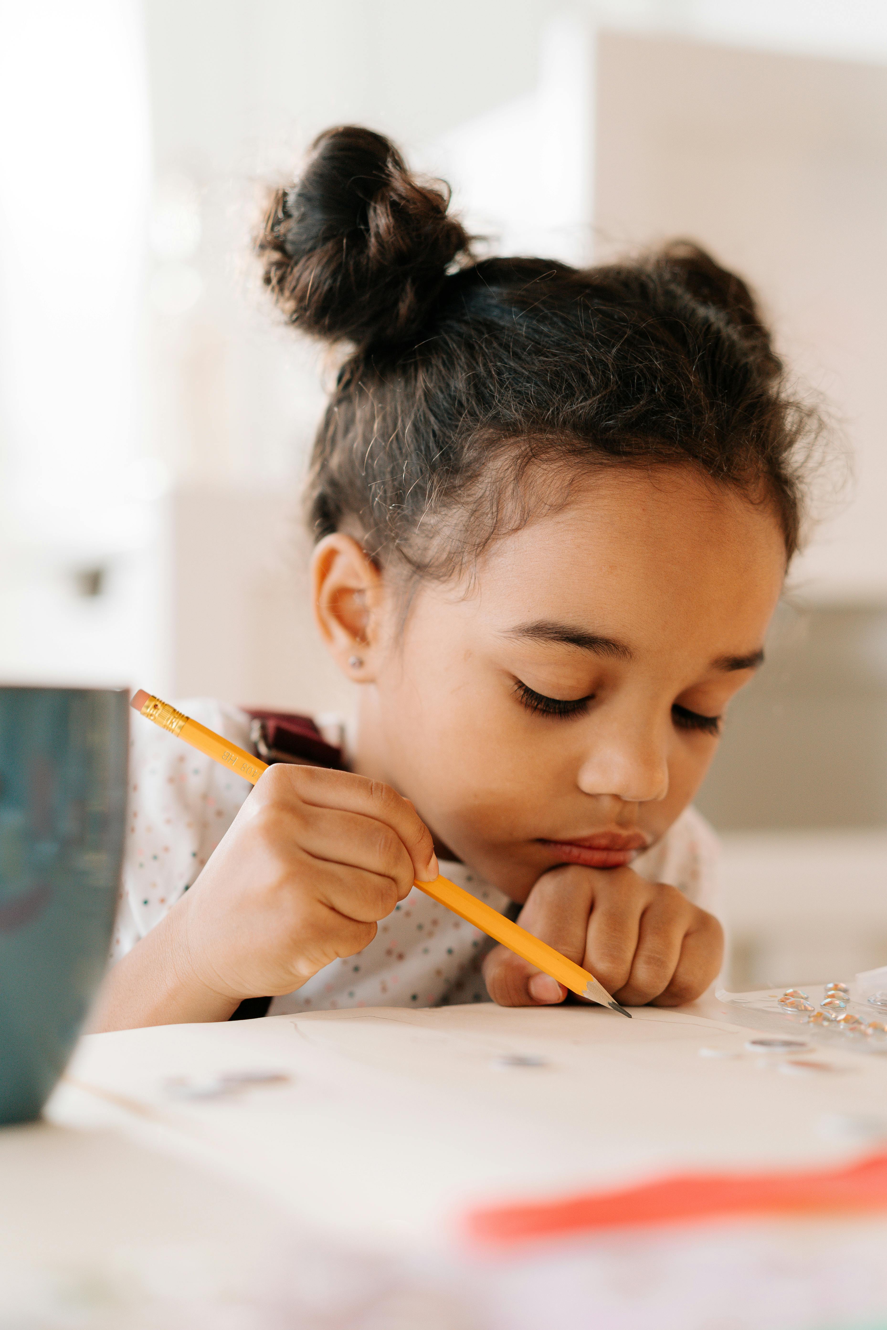 Girl holding a pencil | Source: Pexels