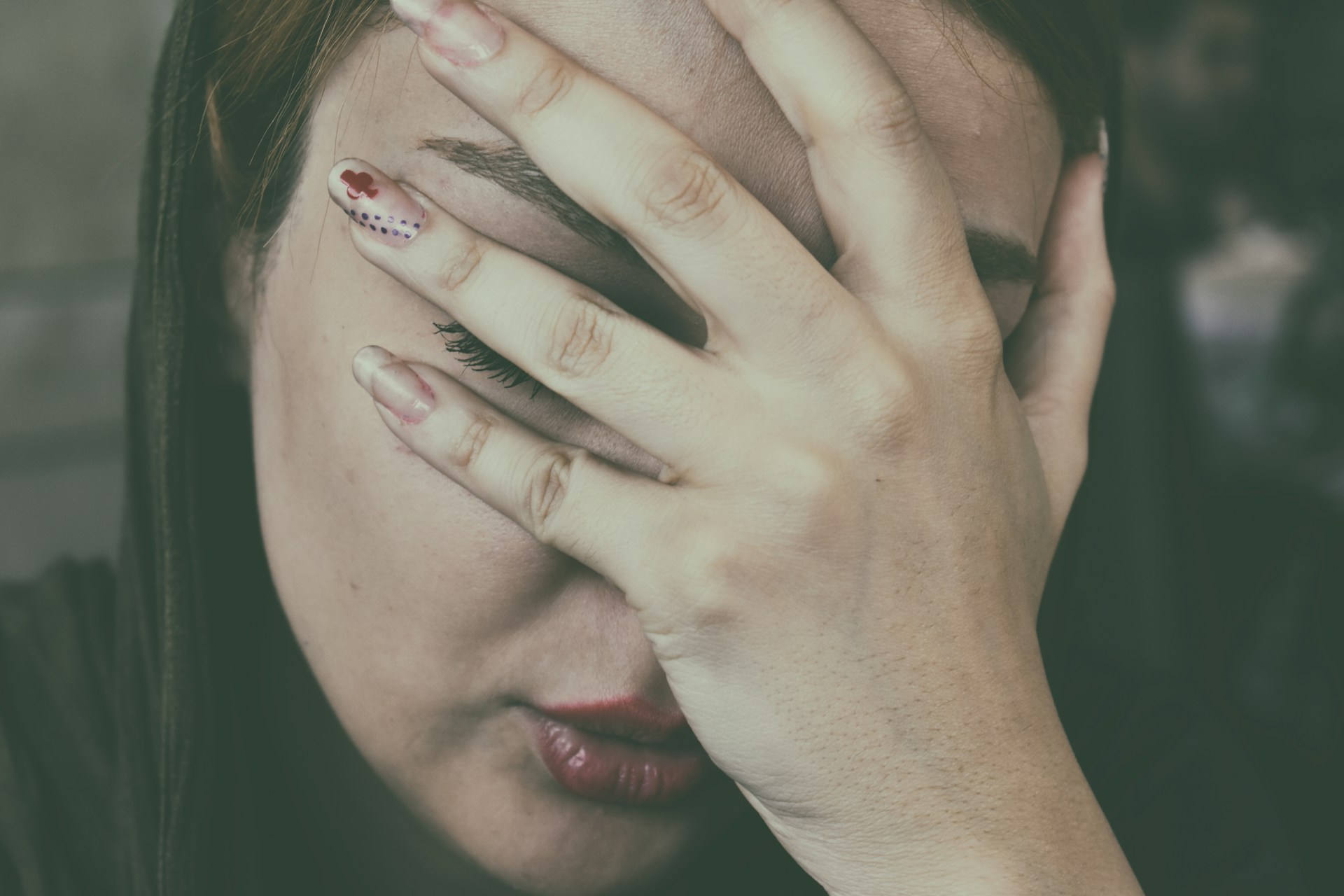 Uma mulher apoiando a cabeça nas mãos | Fonte: Unsplash
