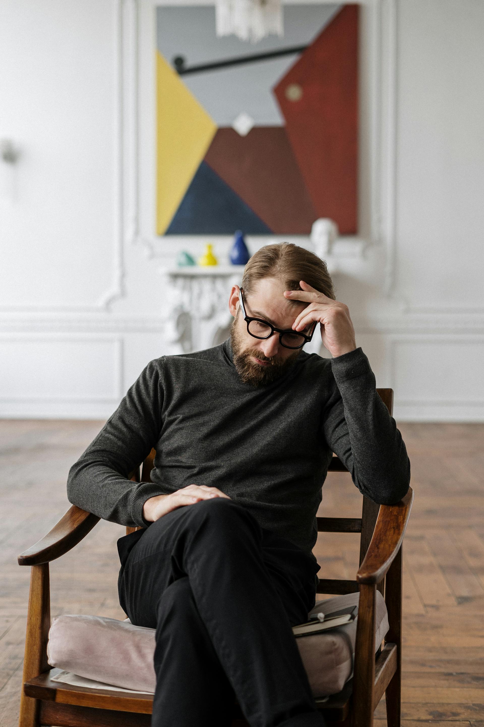 A man sitting on a brown wooden chair | Source: Pexels