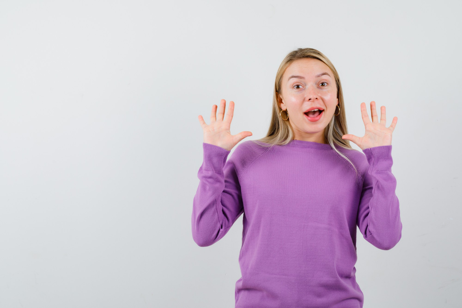 A woman shrugging with delight | Source: Freepik