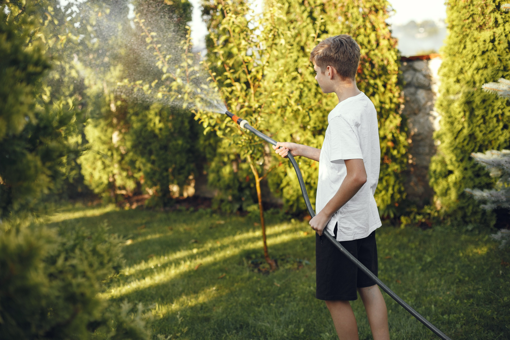 A boy watering plants | Source: Freepik