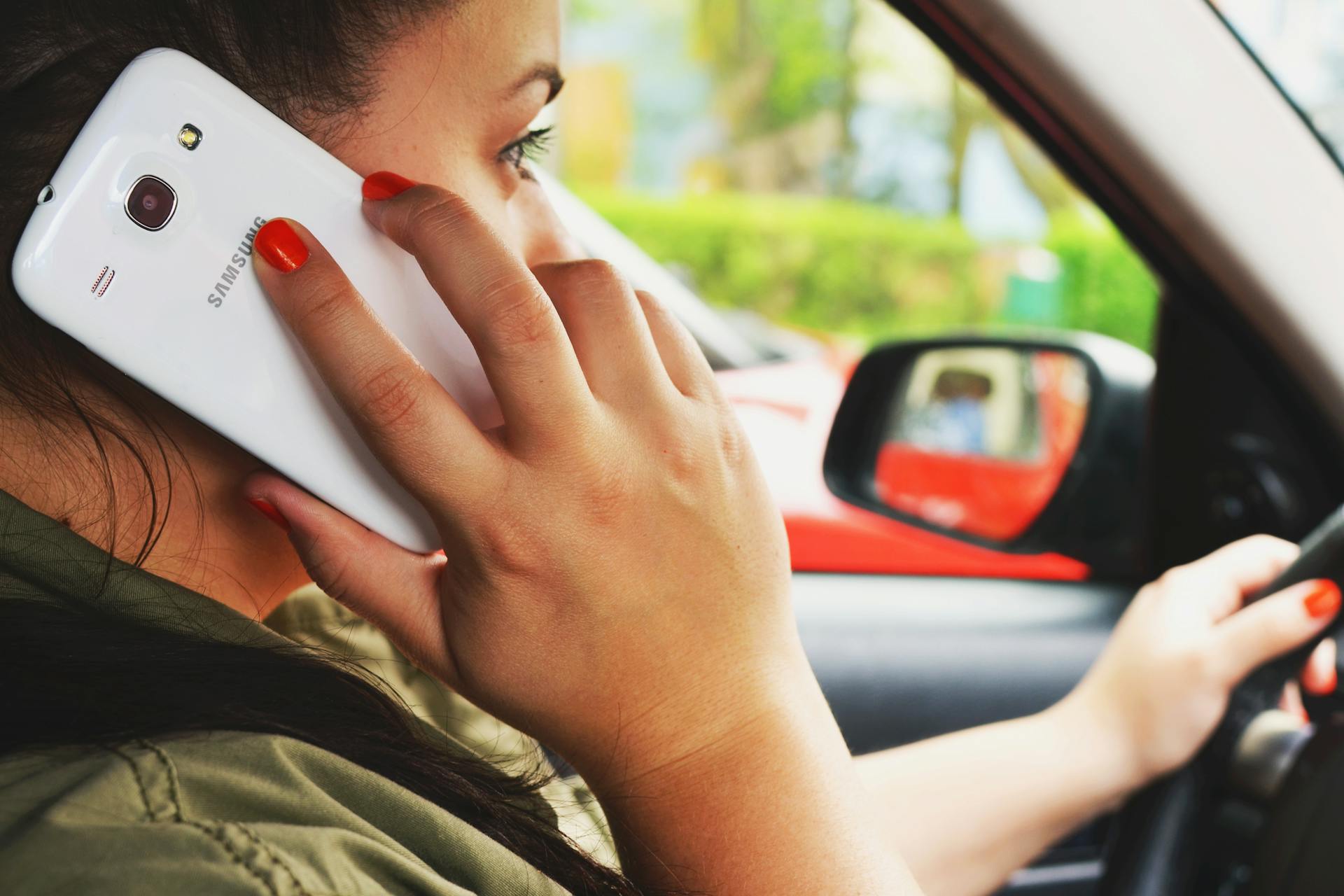A woman in a car speaking on her cell phone | Source: Pexels