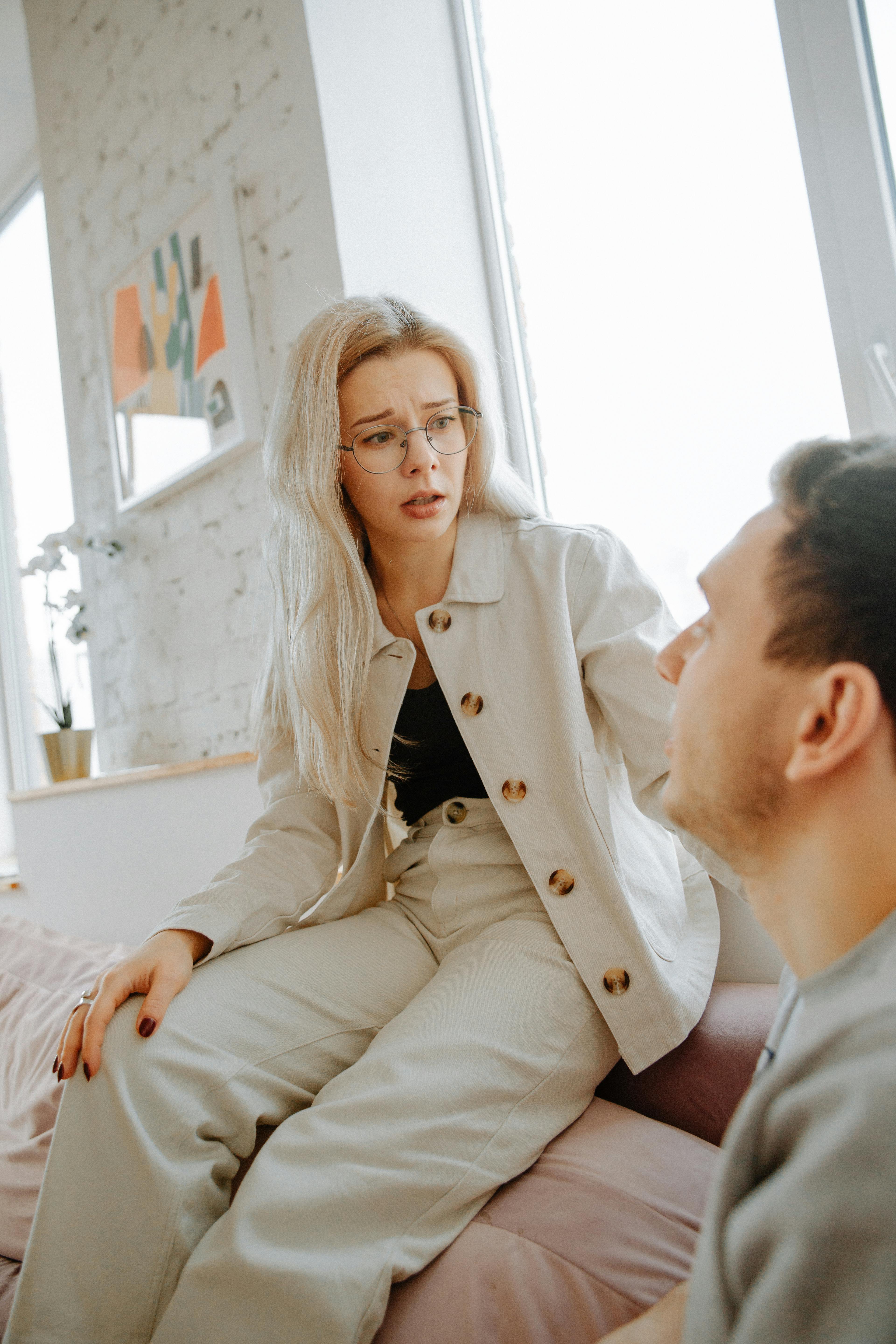 A sad-looking woman talking to a man | Source: Pexels