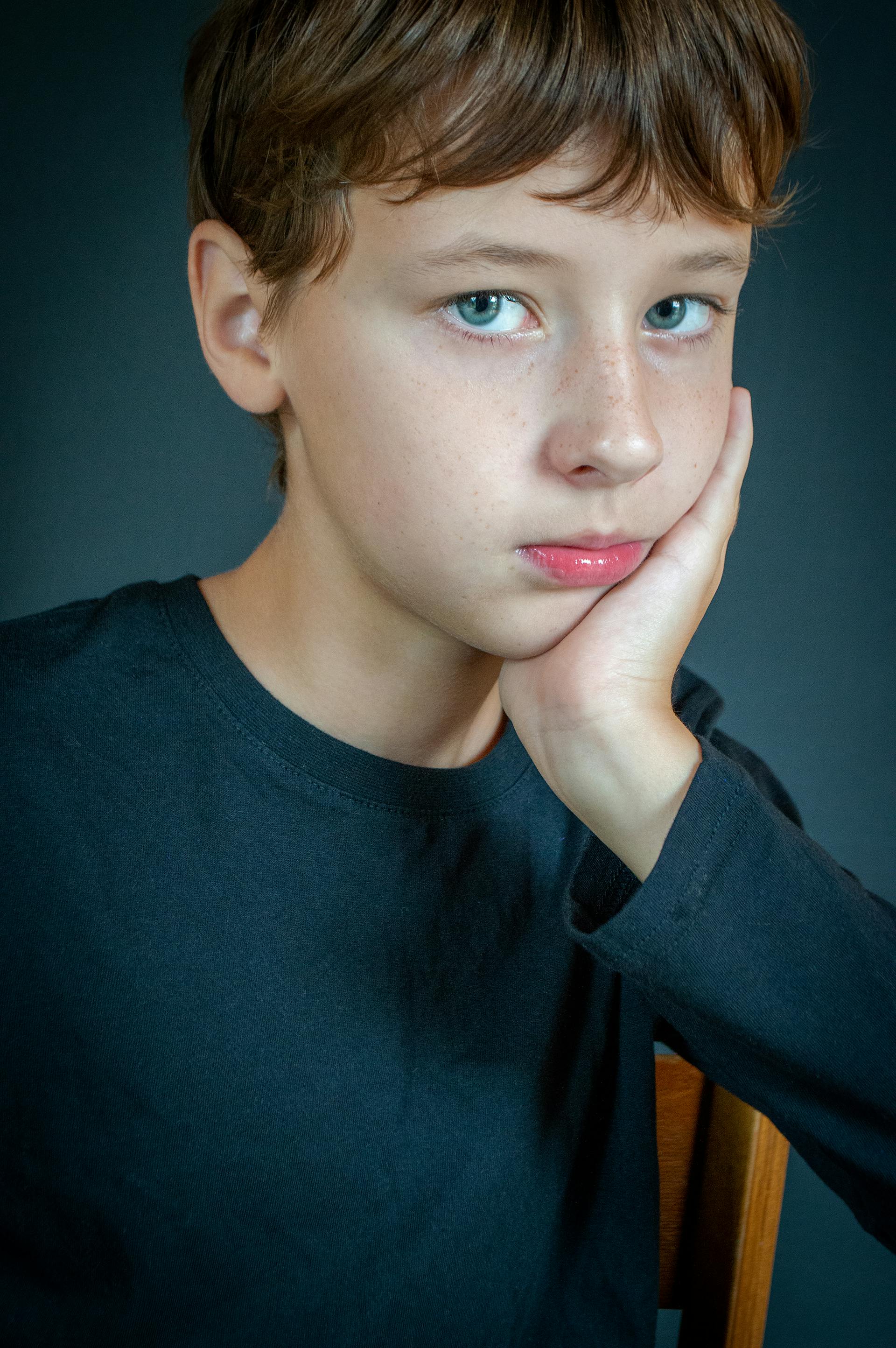 A teenage boy with a hand resting on his cheek | Source: Pexels