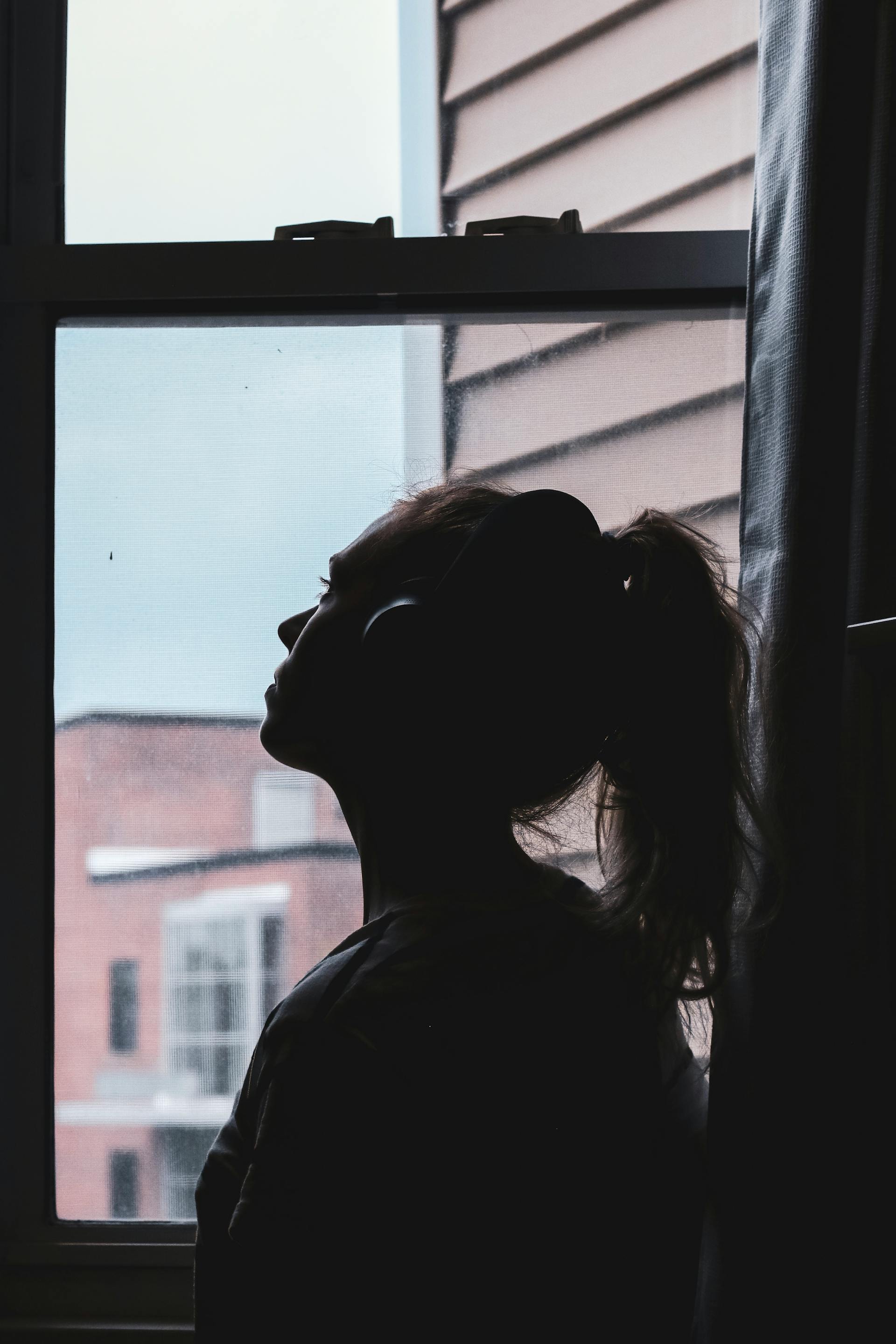 A young woman looking through the window | Source: Pexels
