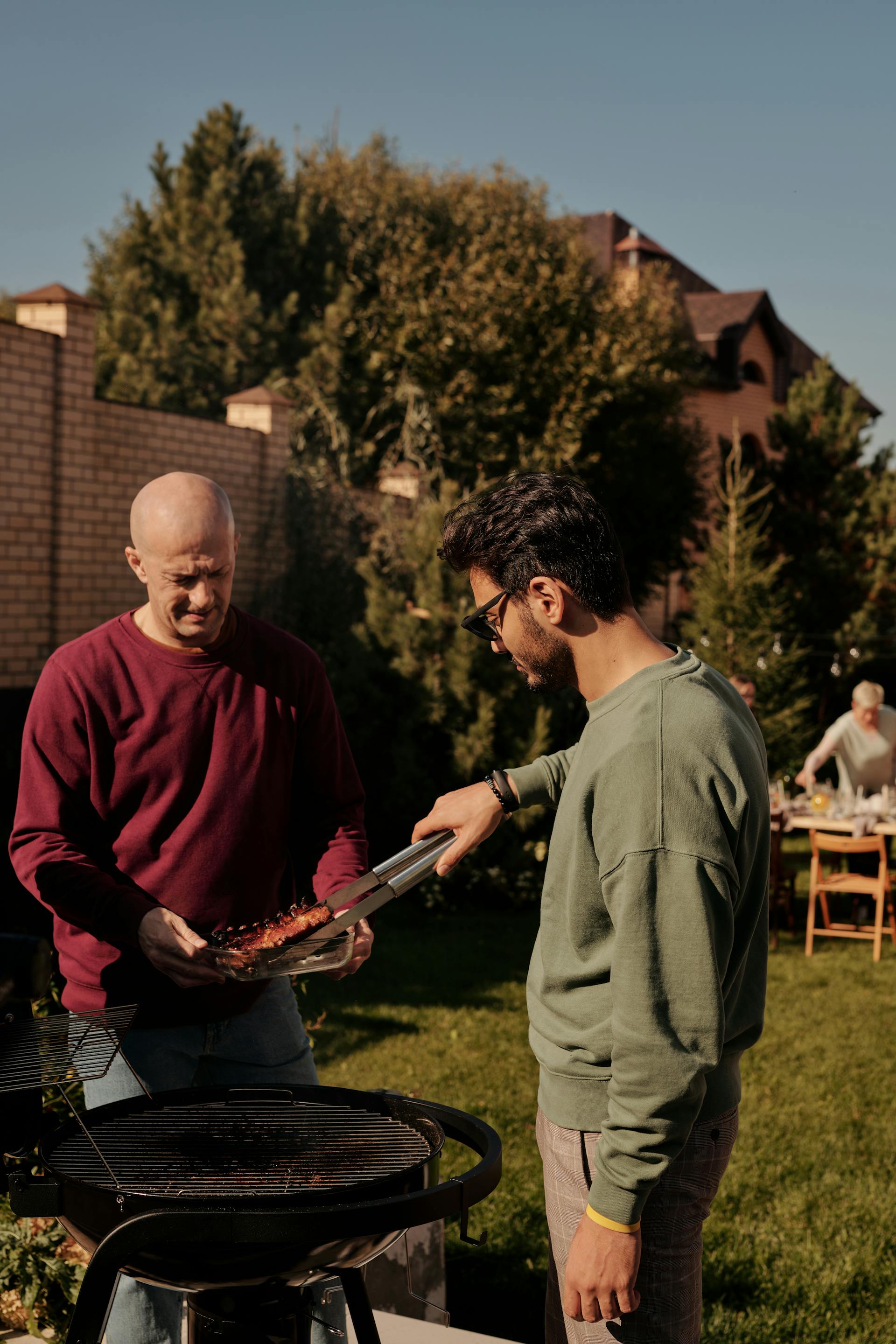 Two men barbecuing in a backyard | Source: Pexels