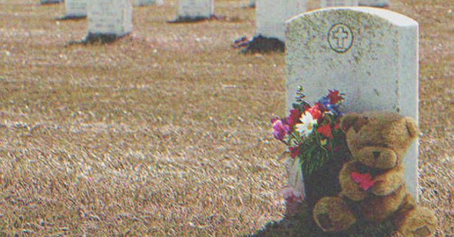 A teddy bear and some flowers next to a grave | Source: Shutterstock