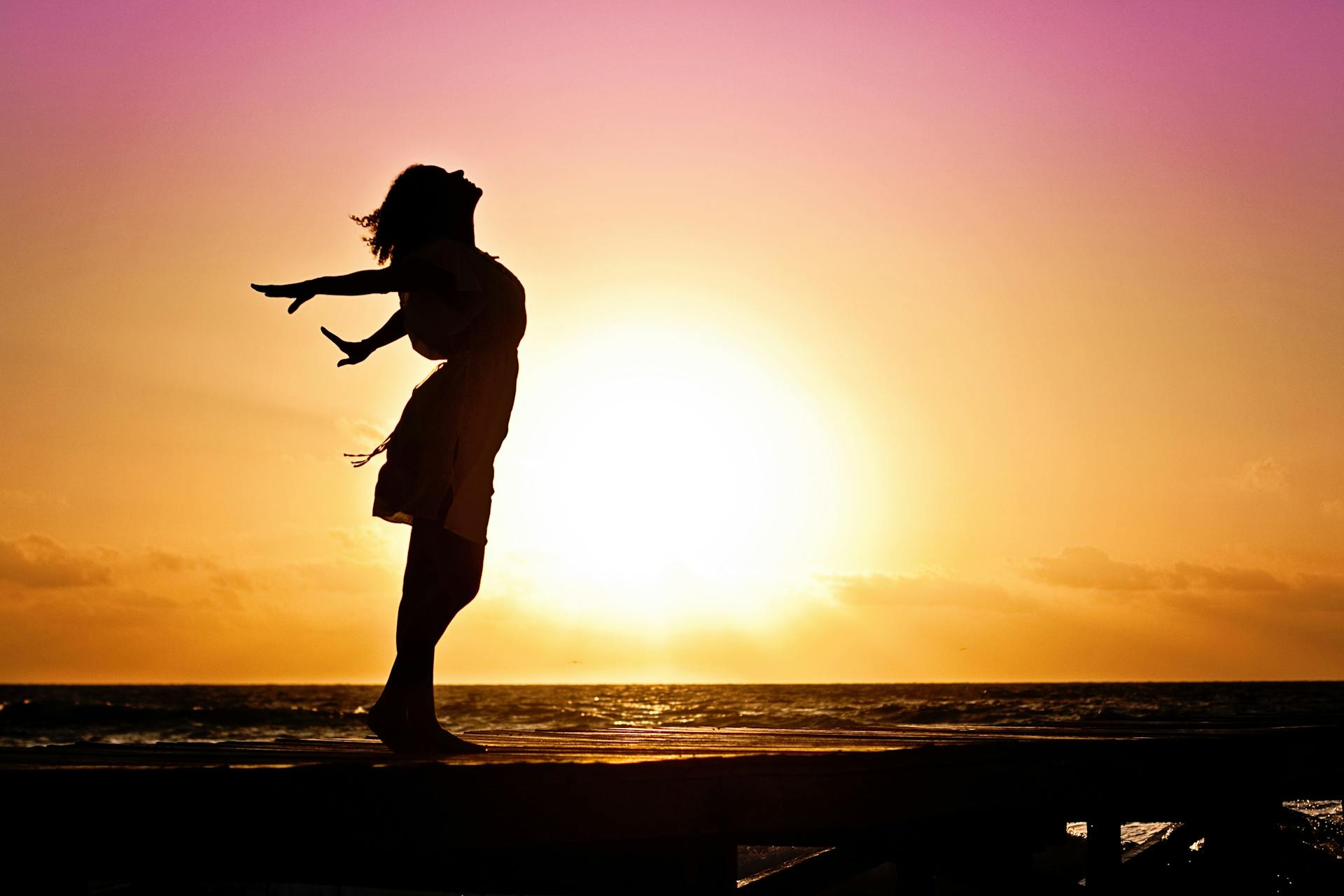 Silhouette of an independent and happy woman on the beach | Source: Pexels