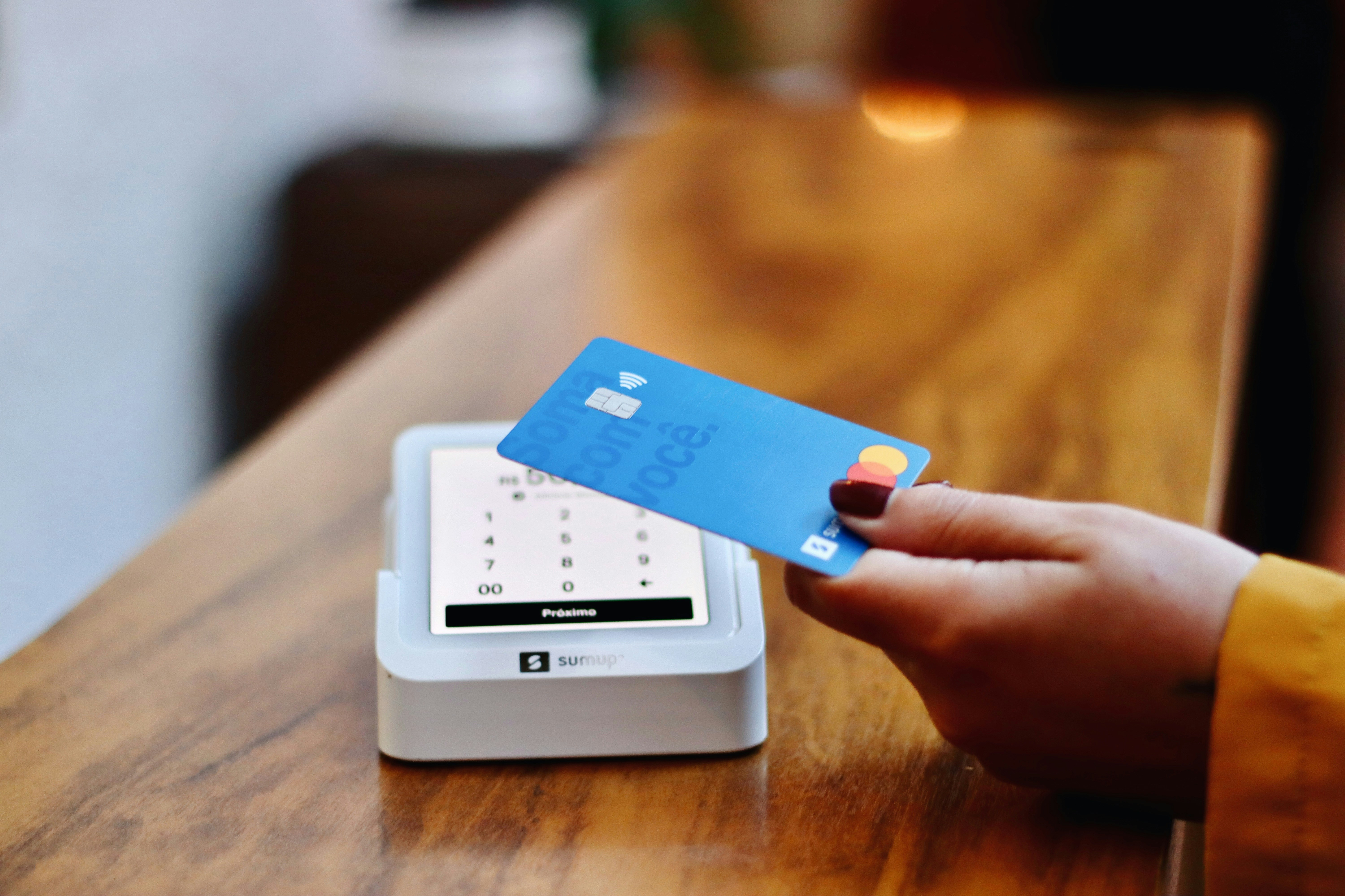 A person holding a card to a machine | Source: Unsplash