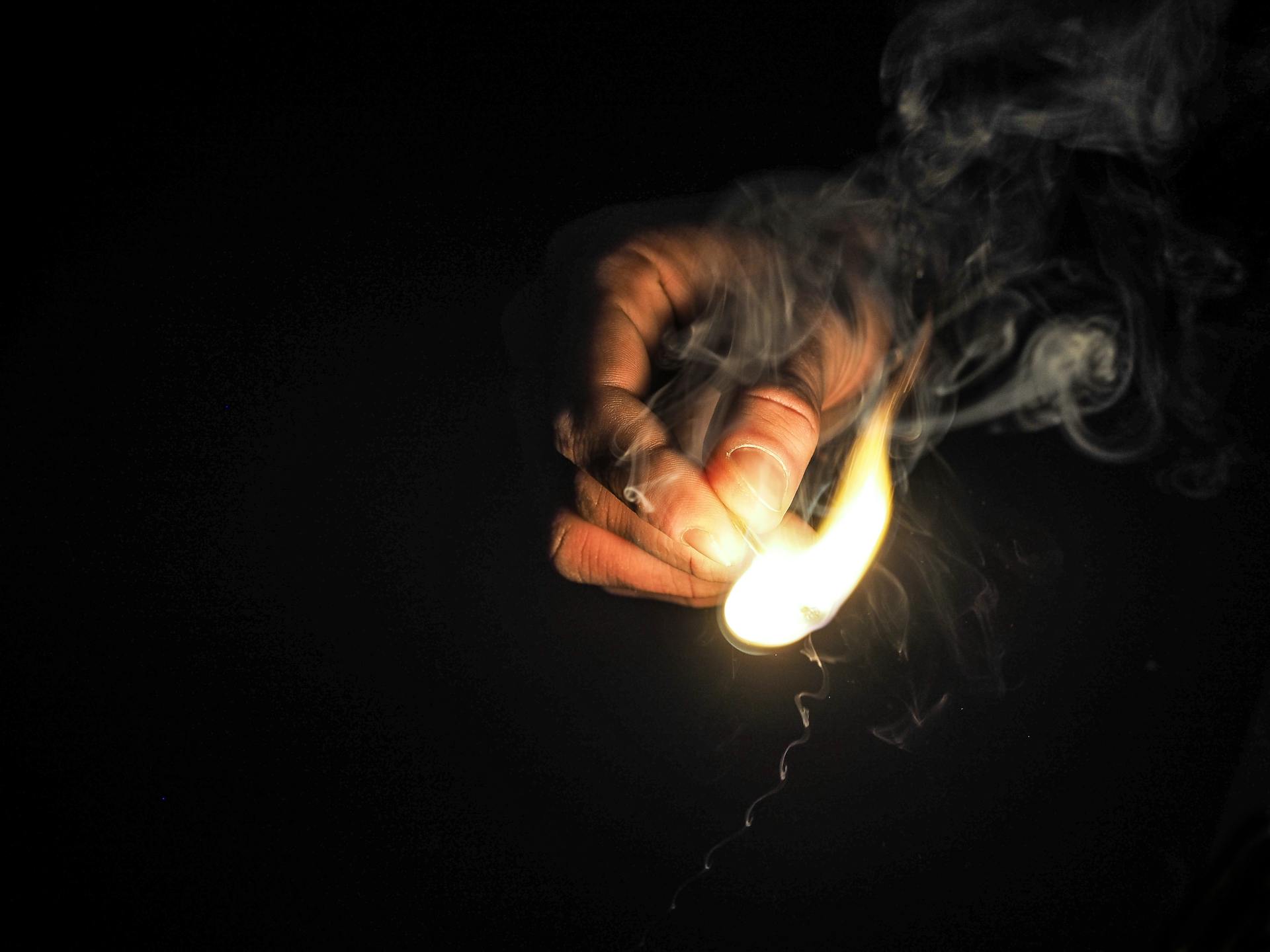 A man holding a lit match | Source: Pexels