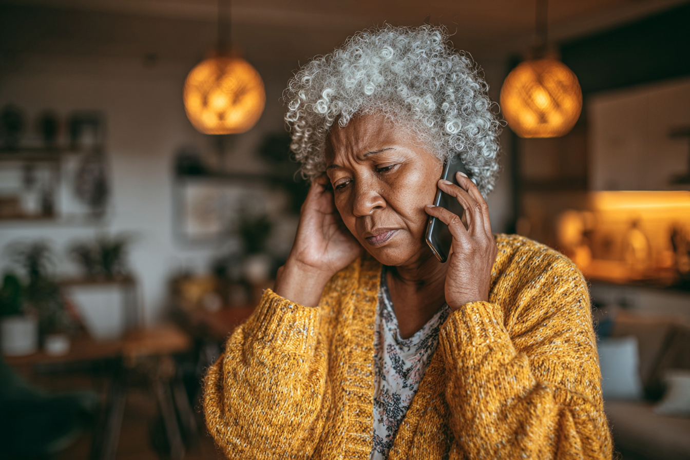 A concerned-looking woman speaking on her cell phone | Source: Midjourney