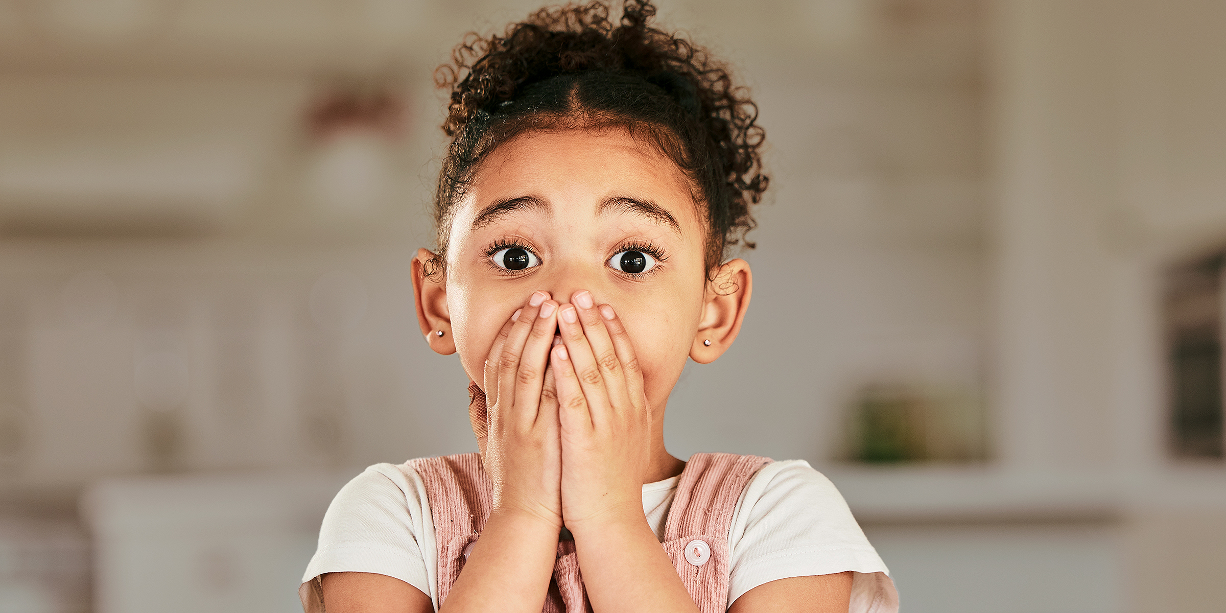 A girl covering her mouth | Source: Shutterstock