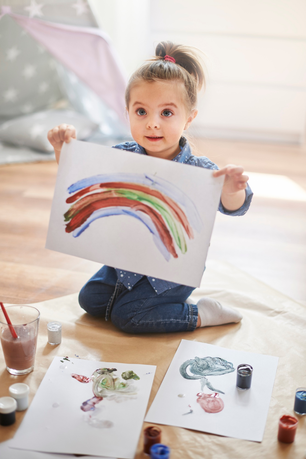 A little girl flaunting her drawing | Source: Freepik