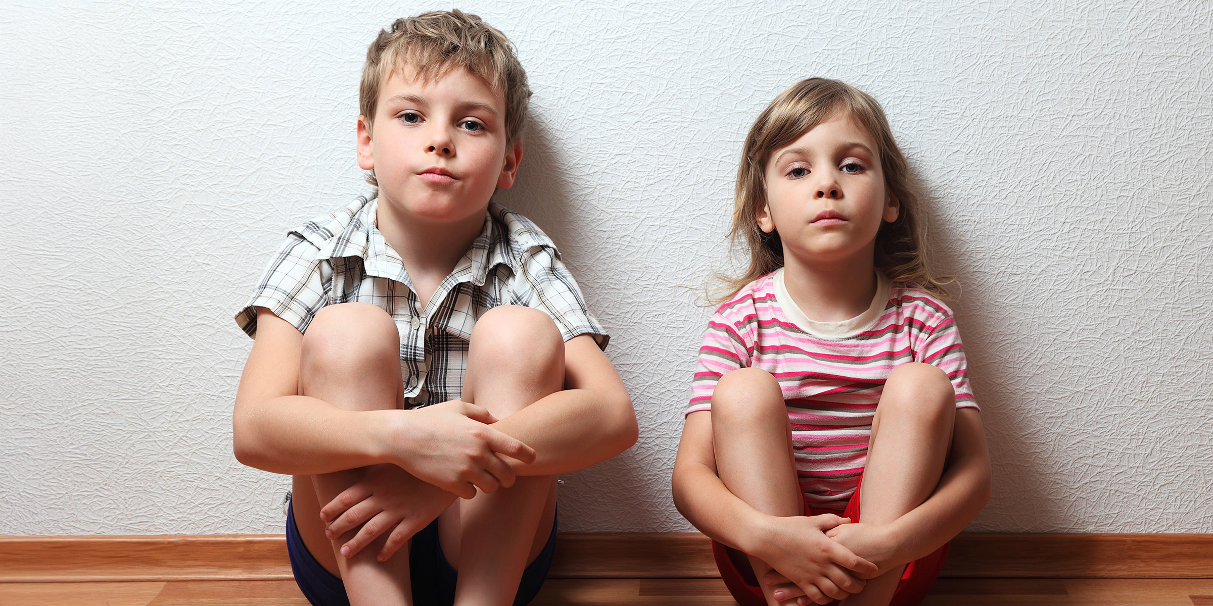 A little boy and girl sitting on the floor | Source: Shutterstock