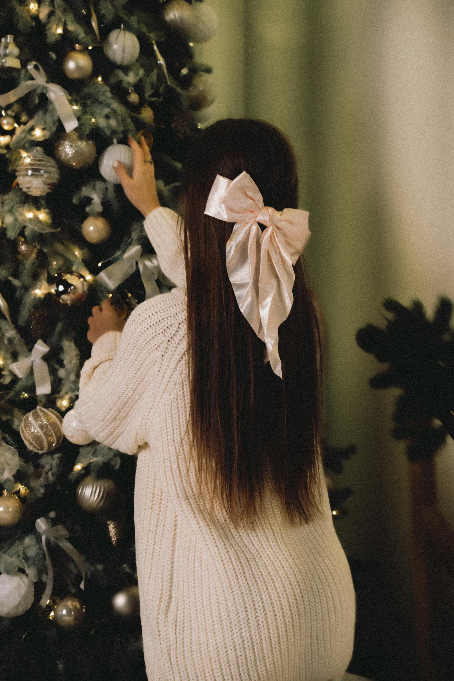 A woman standing near a Christmas tree | Source: Pexels