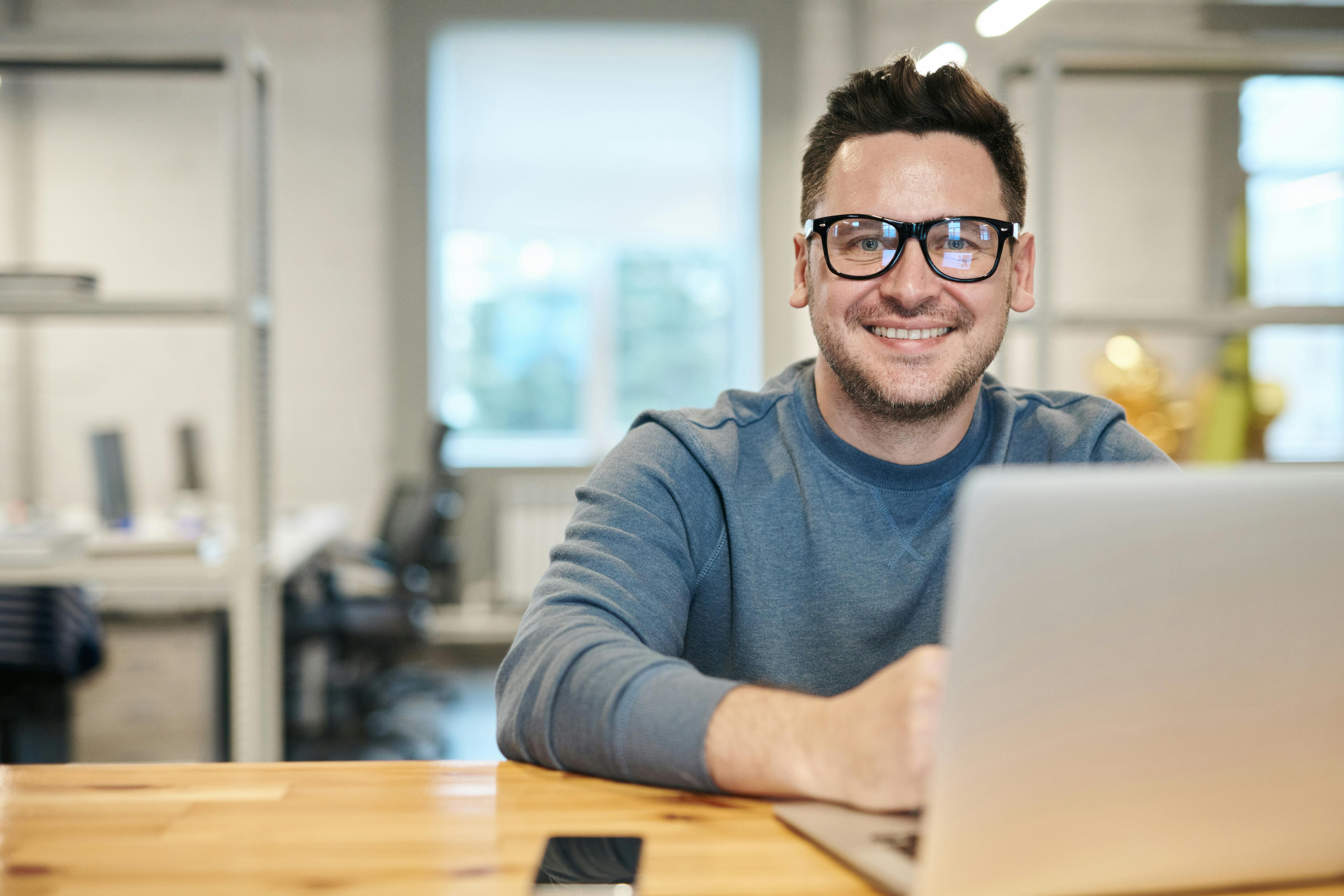 A happy man with a laptop | Source: Pexels