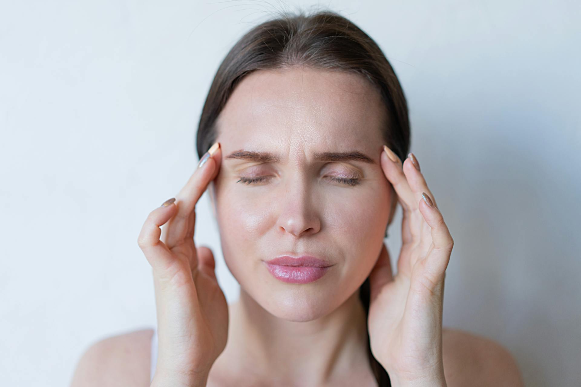 A woman holding her head | Source: Pexels