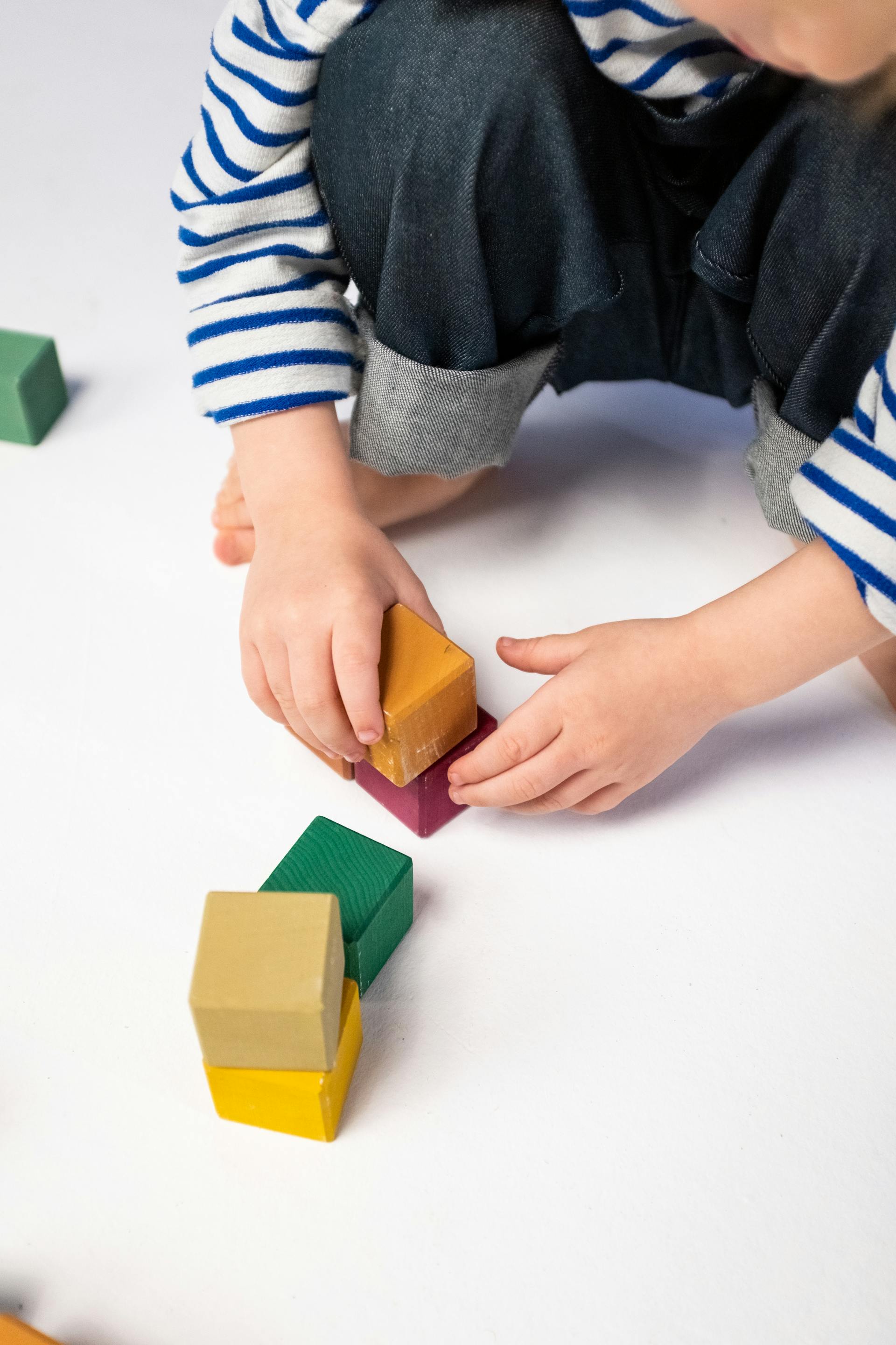 A close-up shot of a boy playing with plastic blocks | Source: Pexels