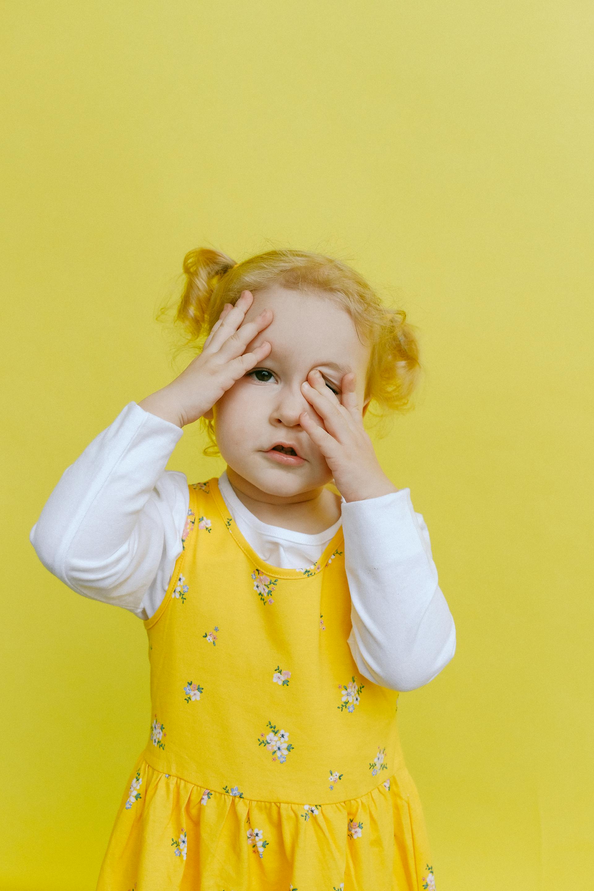 A little girl covering her face with her hands | Source: Pexels