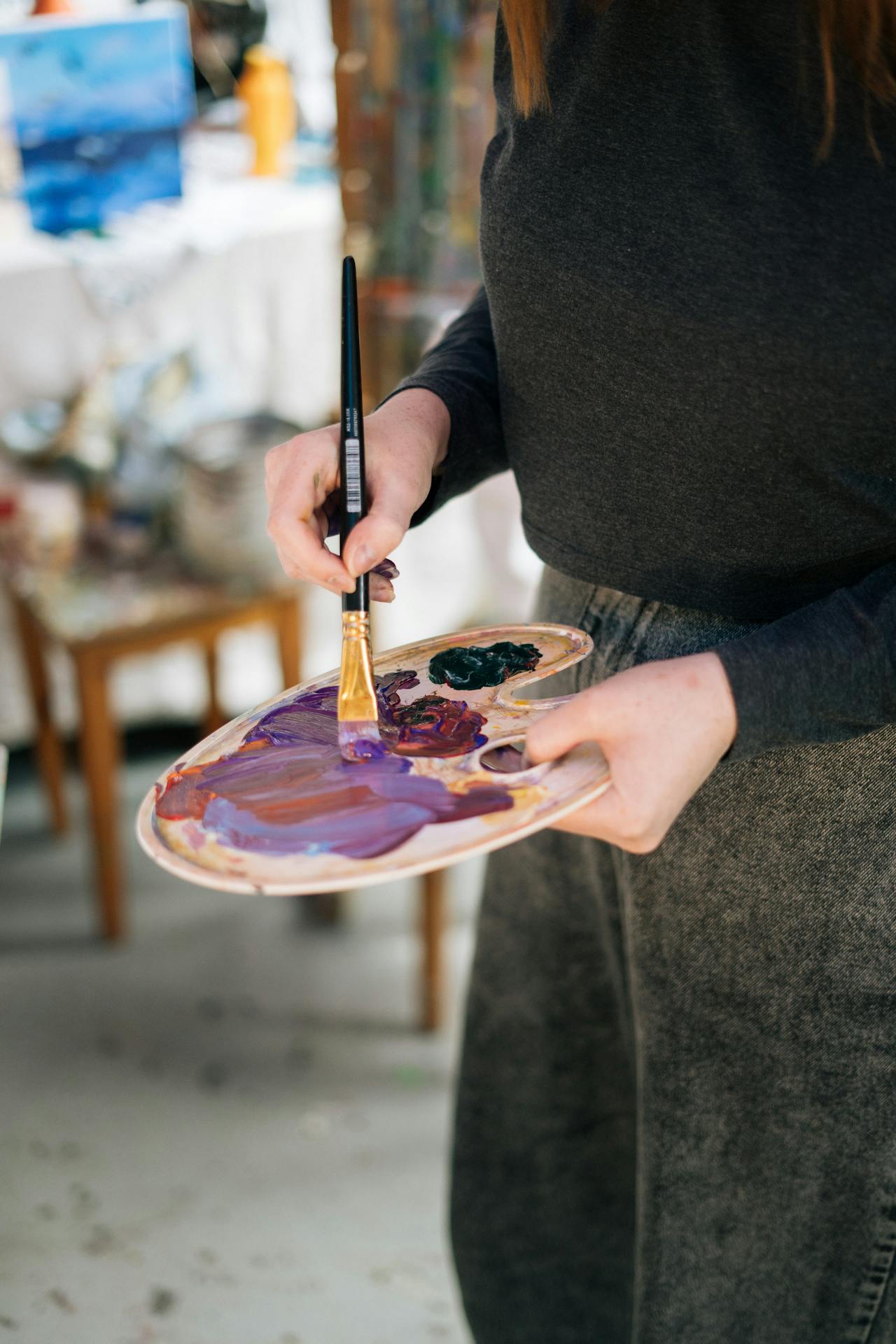 A woman holding a paint palette and brush | Source: Pexels