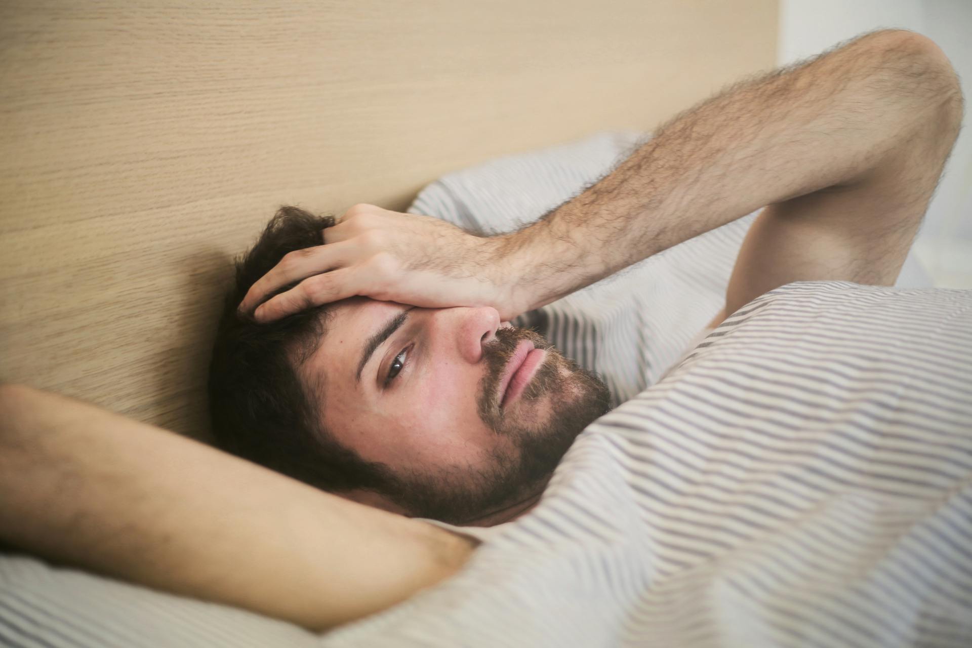 Um homem deitado na cama | Fonte: Pexels