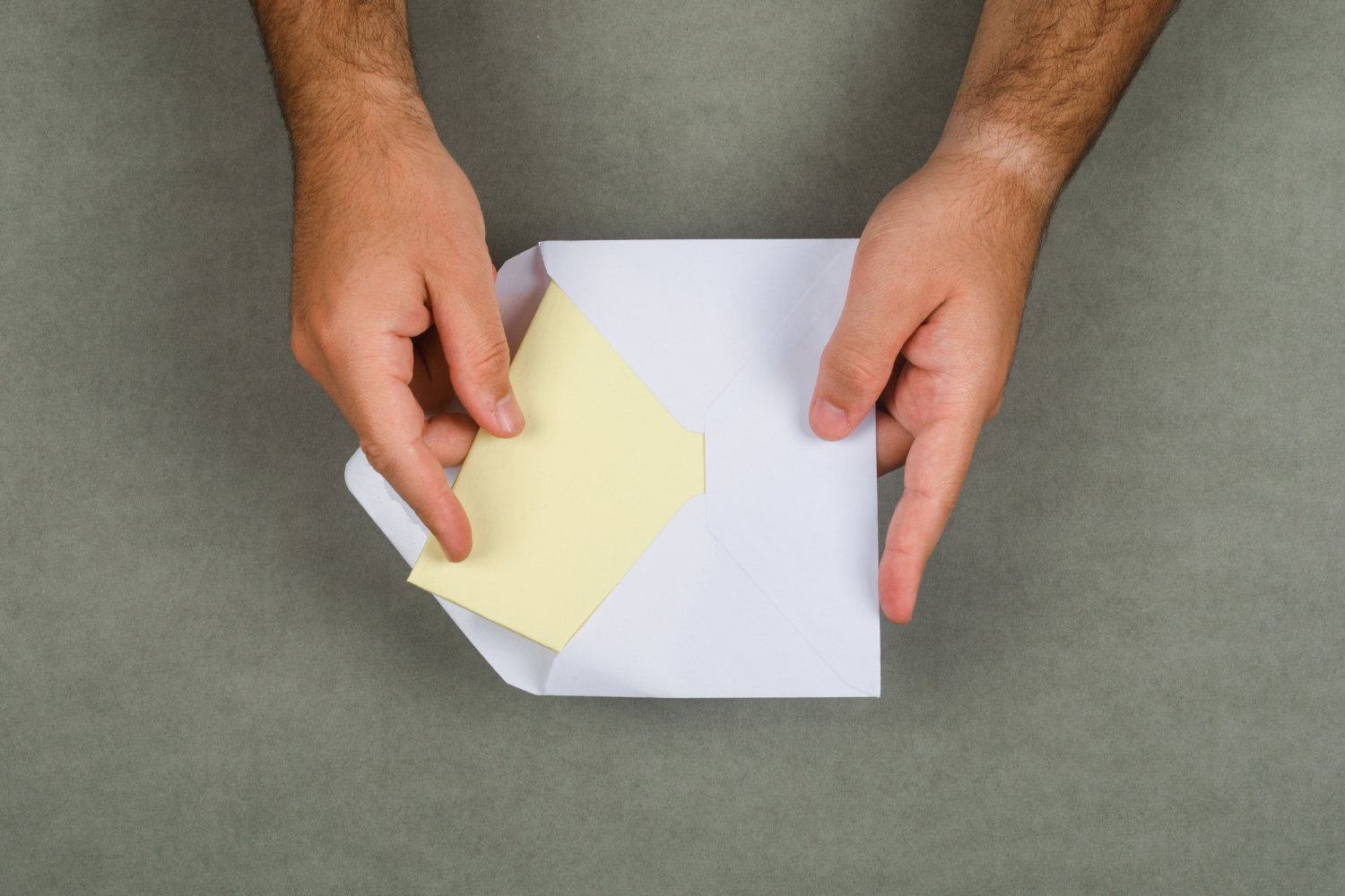 A man taking a letter out of an envelope | Source: Freepik