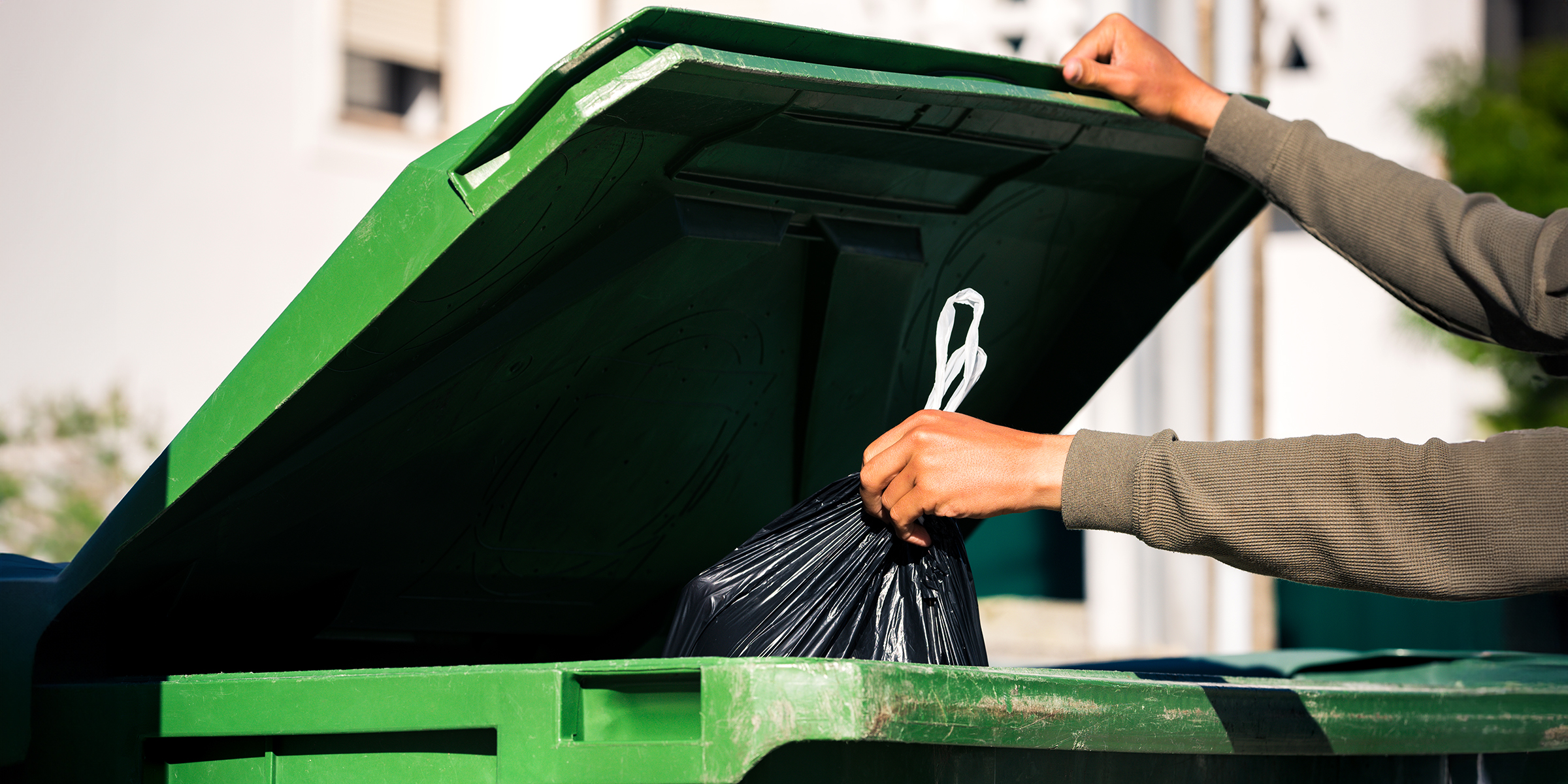 A person throwing trash into a bin | Source: Shutterstock