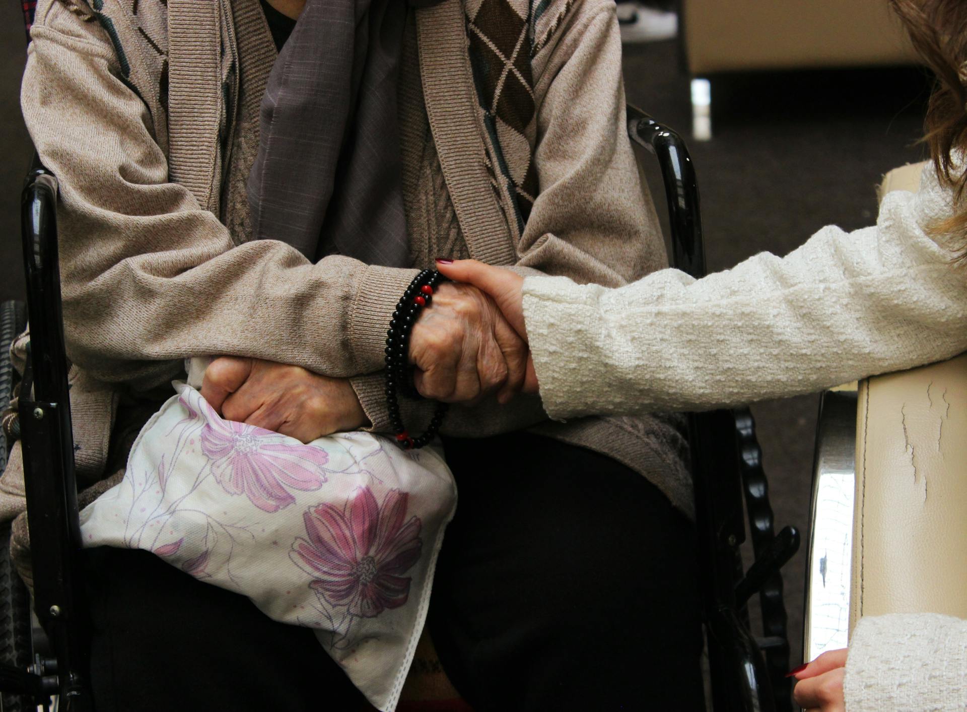 A young woman holding an older person's hand | Source: Pexels