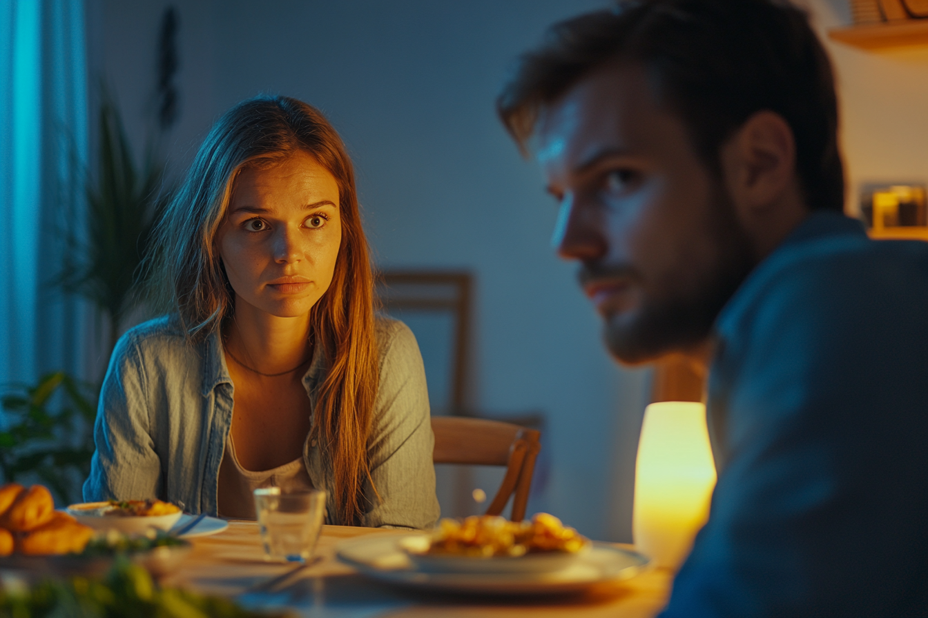 A woman staring at her husband during dinner | Source: Midjourney