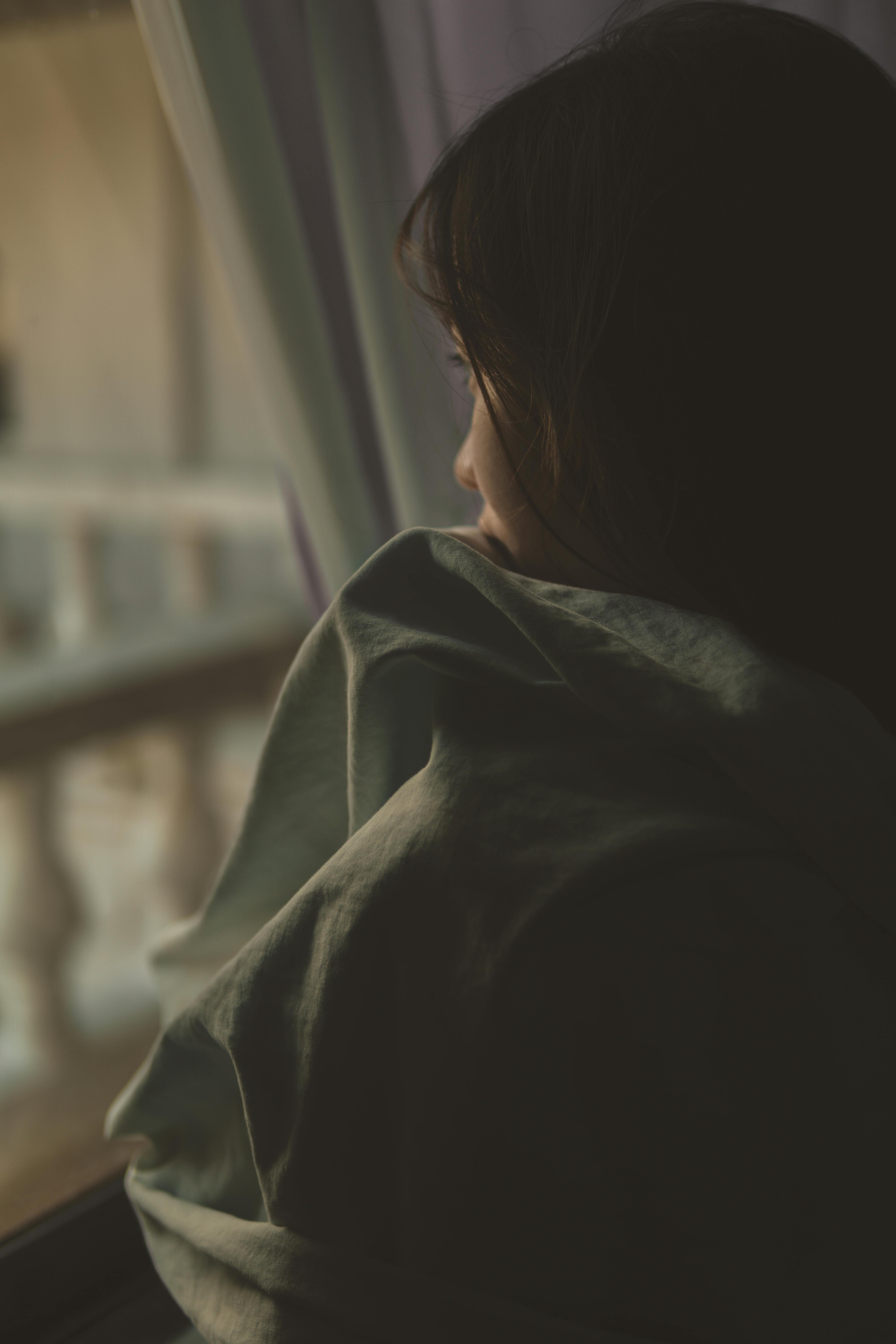A sad woman looking out a window | Source: Pexels