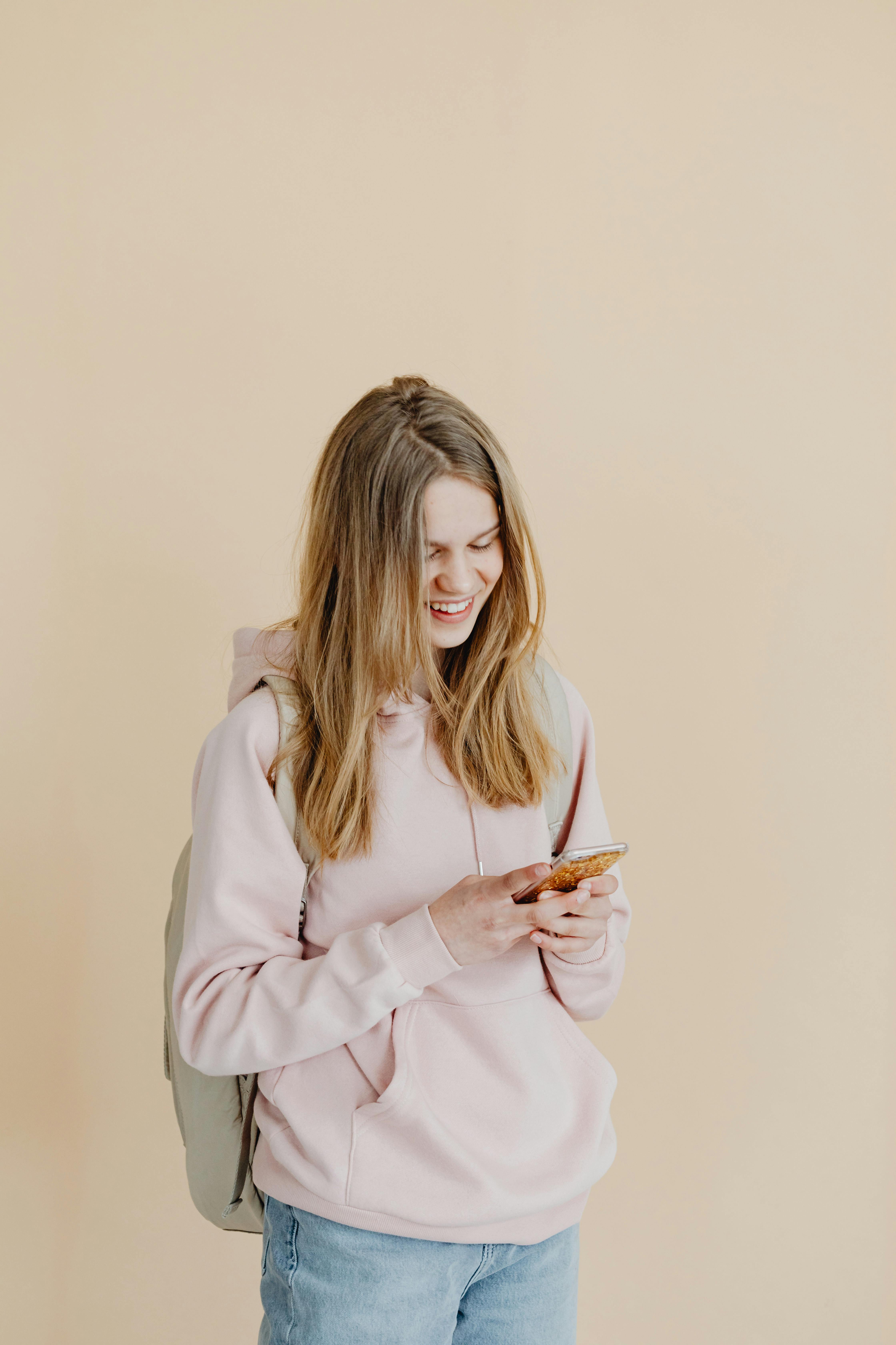 A happy girl looking at her phone | Source: Pexels