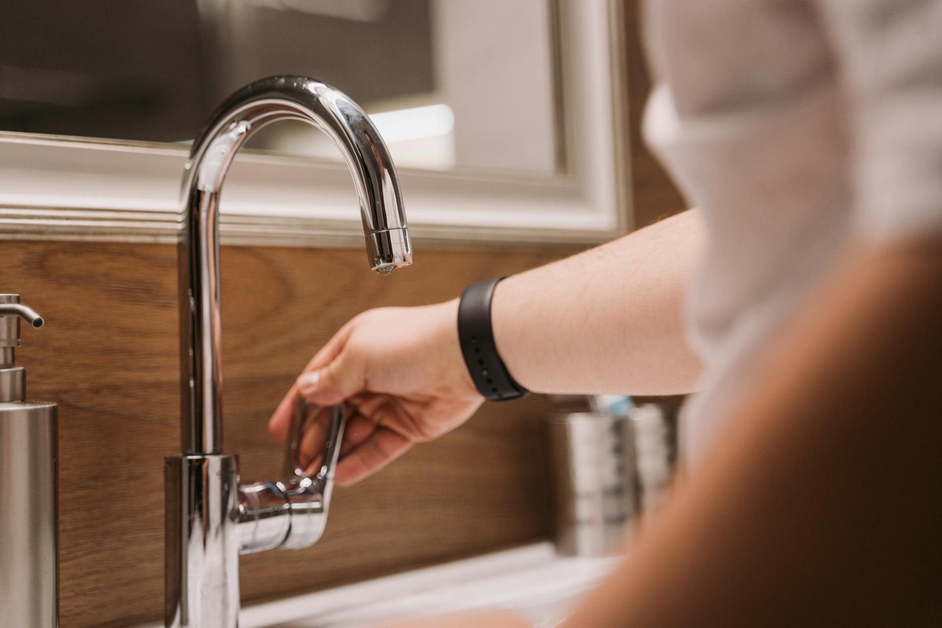 Close-up shot of a person holding a faucet handle | Source: Pexels