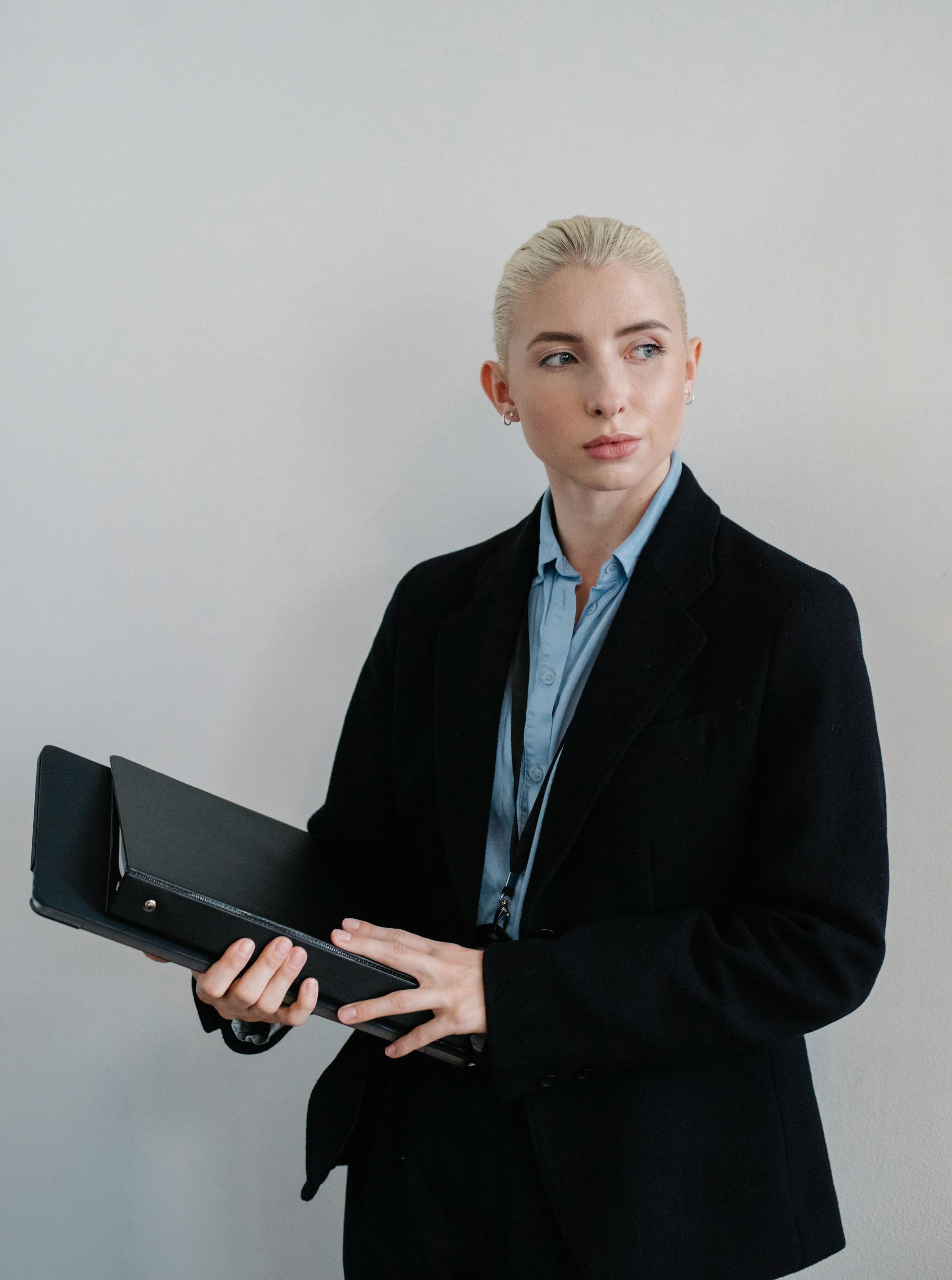 A woman in a black coat carrying folders | Source: Pexels