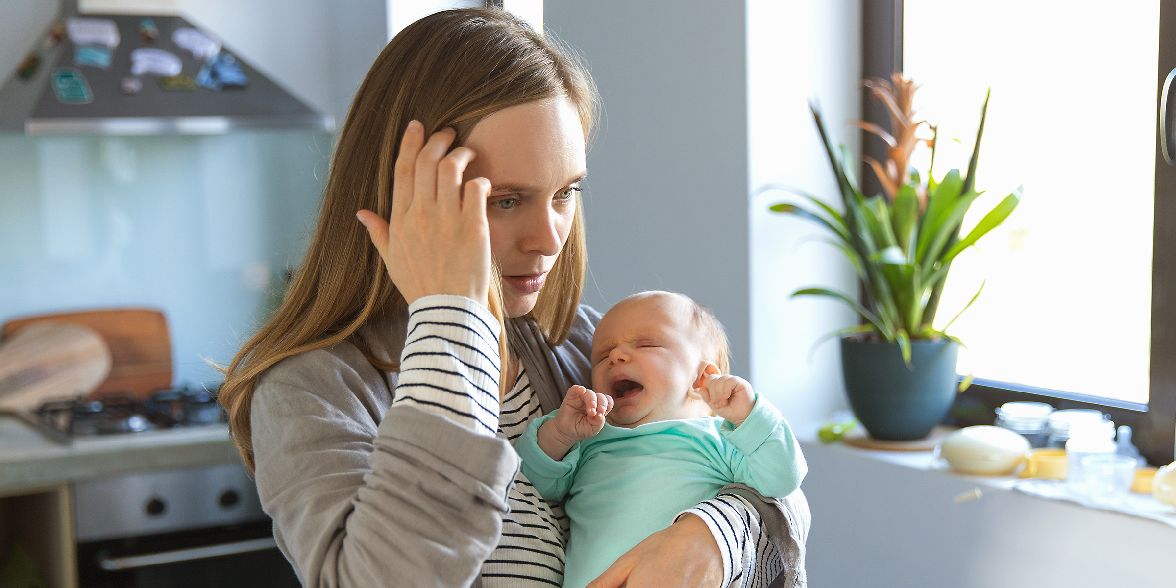 A woman holding a crying baby | Source: Shutterstock