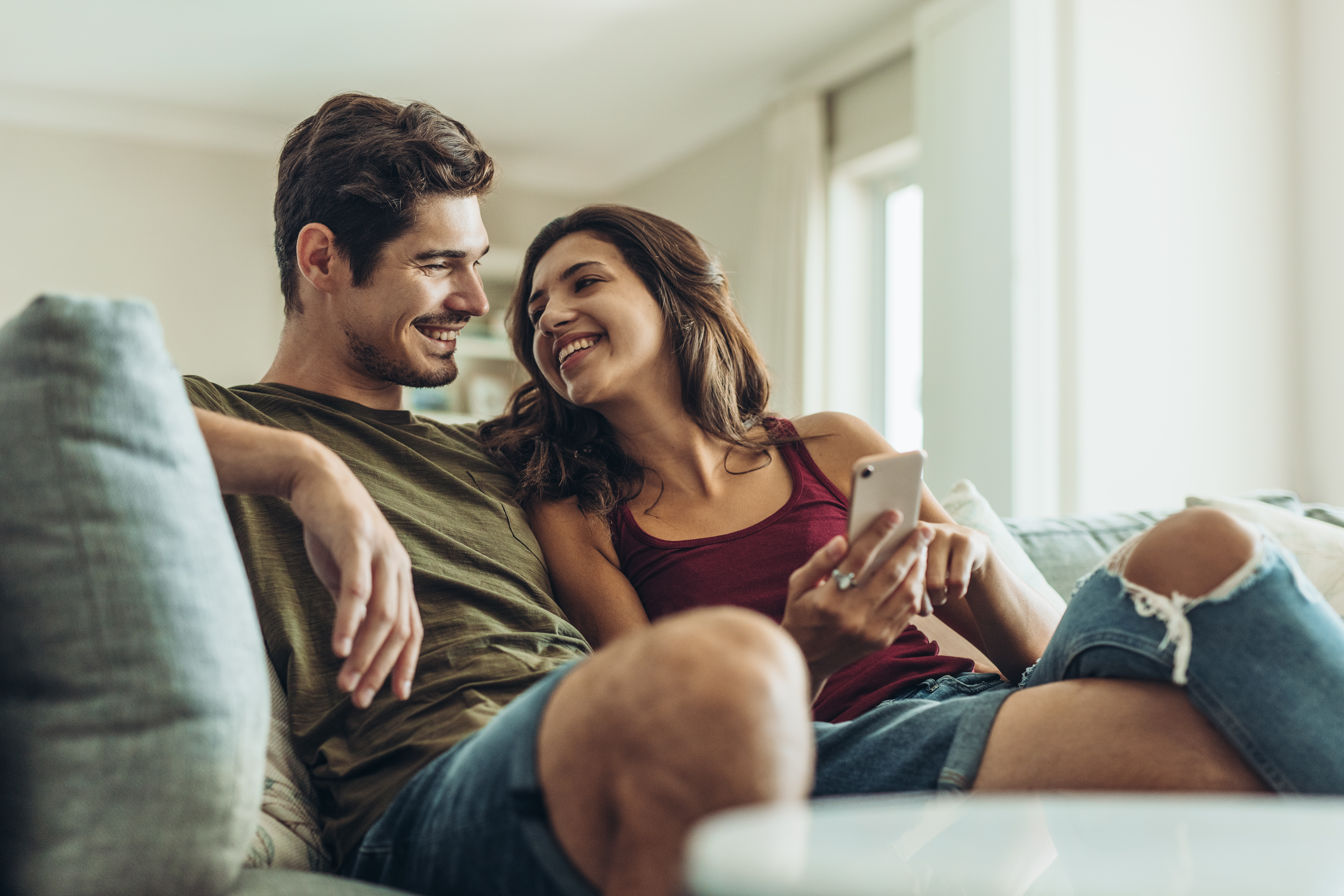A couple chatting while sitting on a sofa | Source: Shutterstock