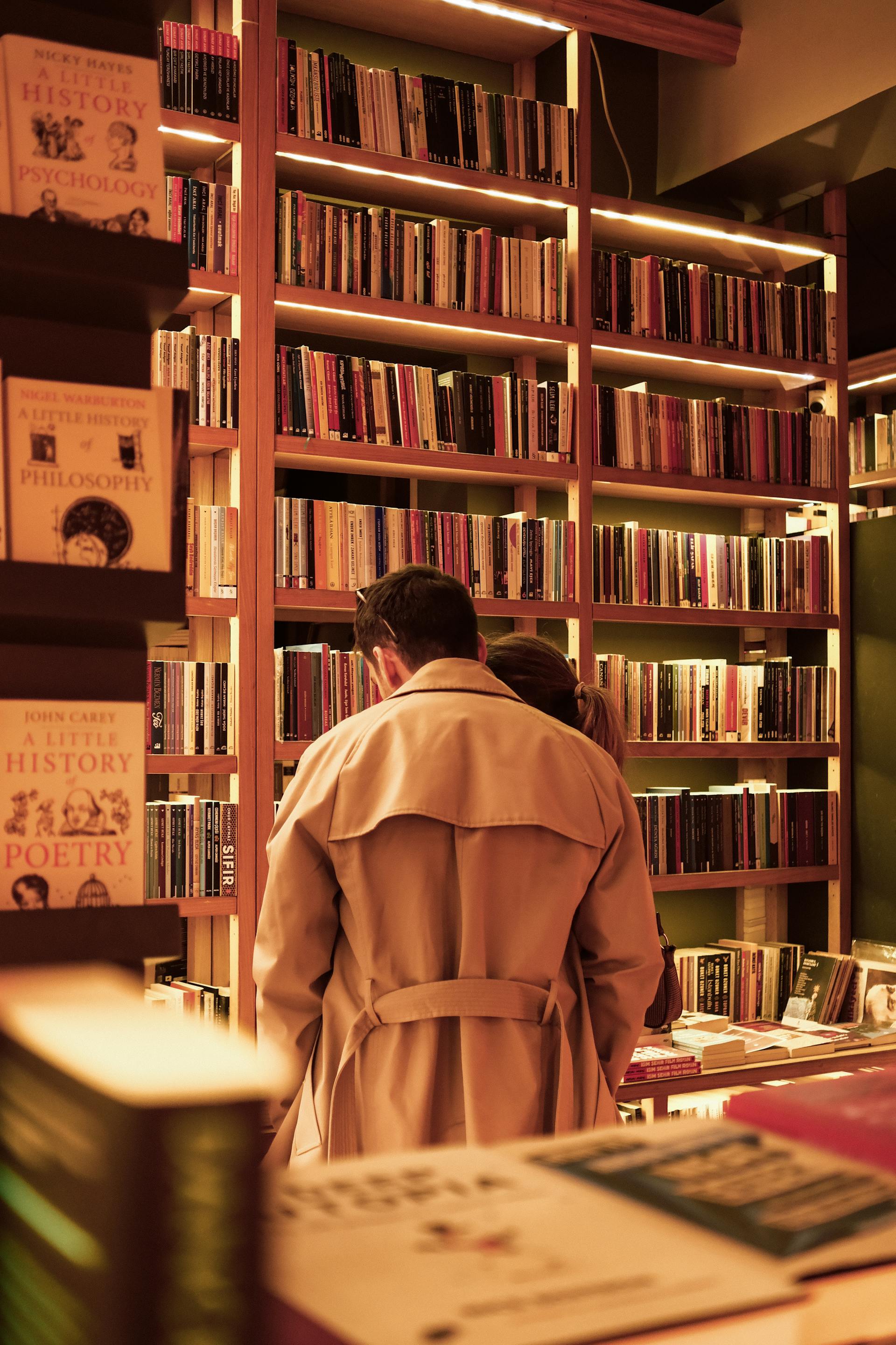 A back-view of a couple standing in a bookstore | Source: Pexels